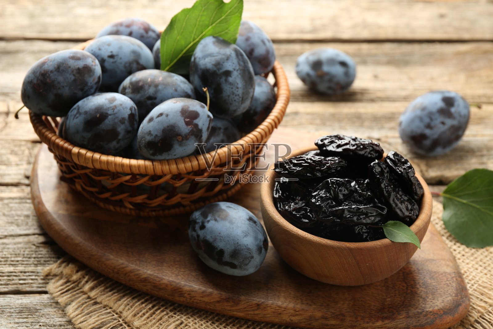 木桌上的干李子和新鲜李子,特写照片摄影图片