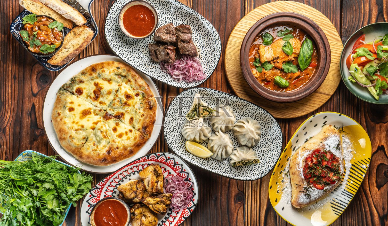 格鲁吉亚传统美食拼盘,包含 Khinkali(格鲁吉亚饺子)、Khachapuri(格鲁吉亚奶酪面包)以及肉类菜肴。照片摄影图片