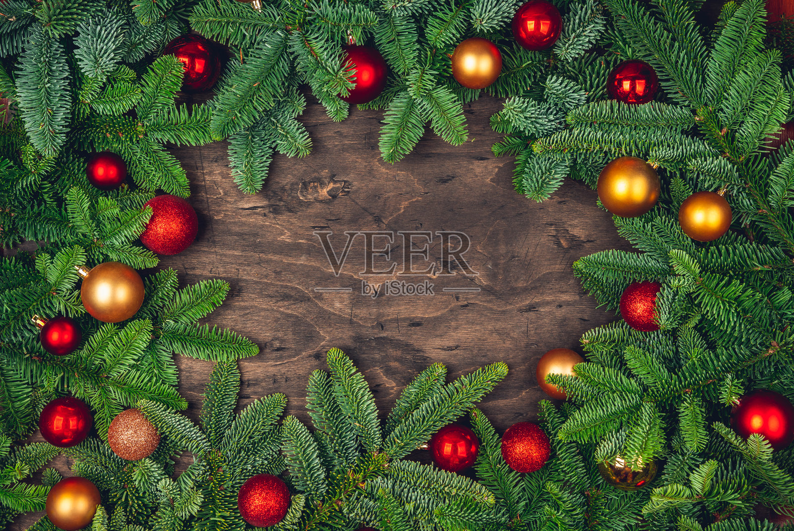 常青的冷杉枝条框架,装饰着红色和金色圣诞球照片摄影图片