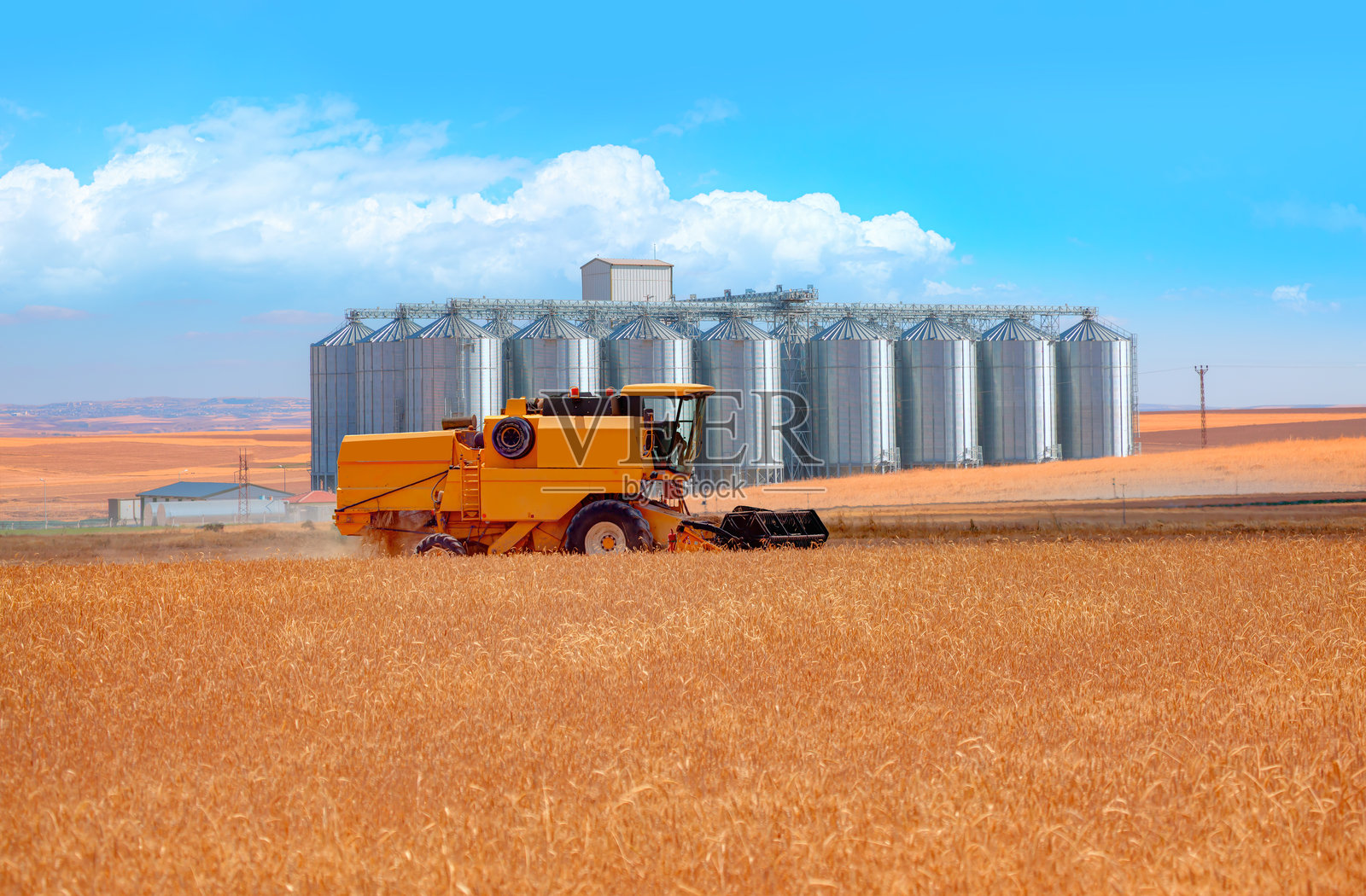 联合收割机收割麦田 - 农用筒仓用于储存和干燥谷物、小麦、玉米、大豆、葵花籽照片摄影图片