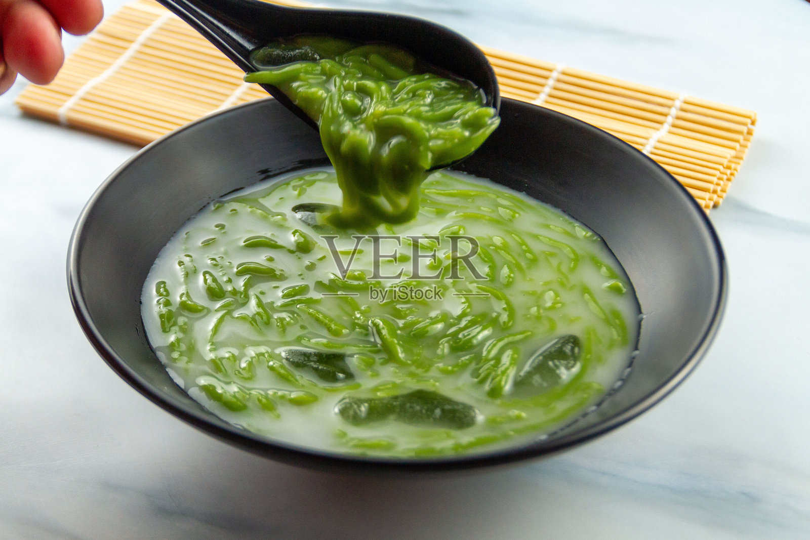 传统印度尼西亚甜点,由冰、米粉冻、棕榈糖和椰奶在玻璃杯中制成,这是一种在斋月期间很受欢迎的清凉饮品。照片摄影图片