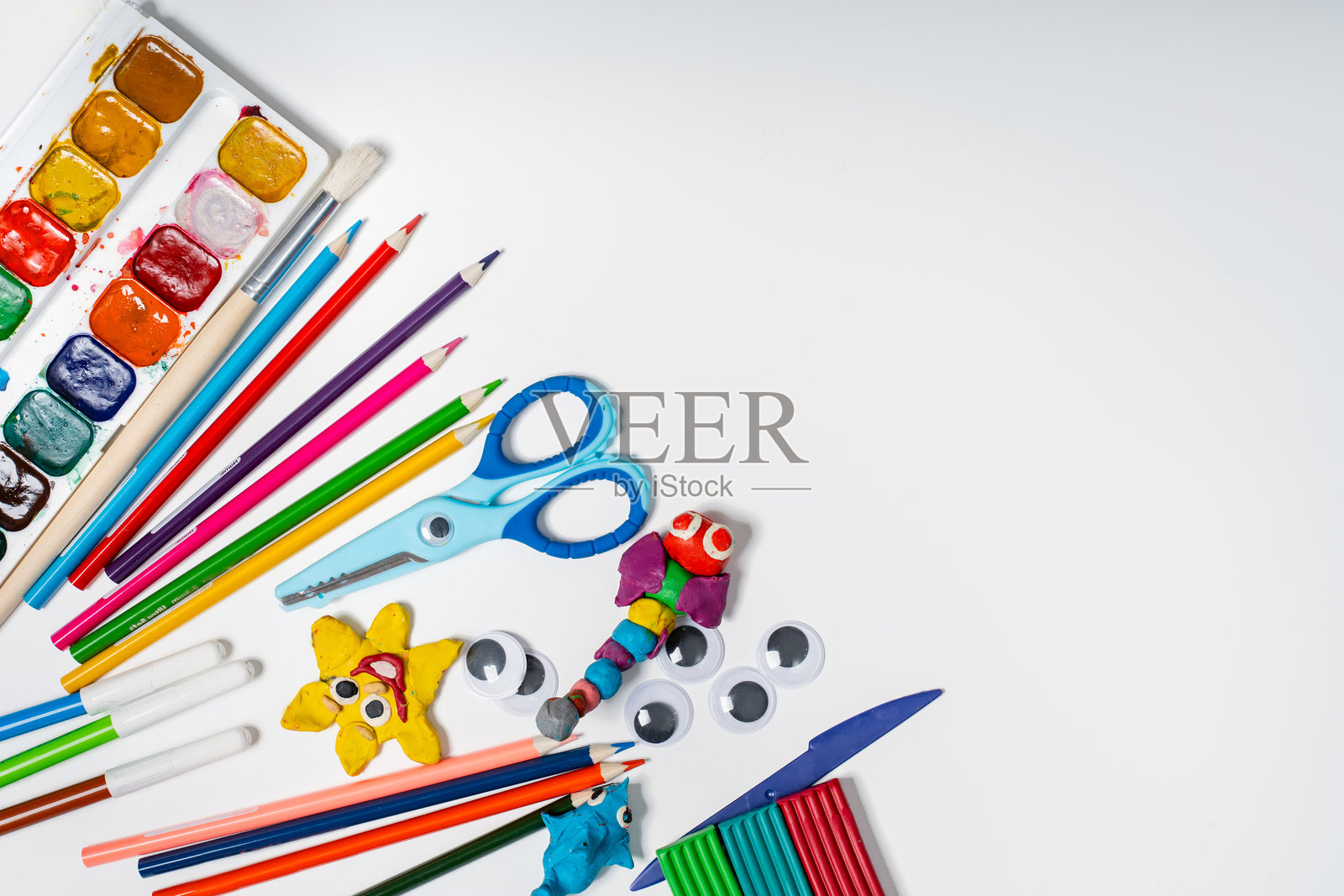 白色背景上的文具,留有文字空间,包括彩色硬纸板、颜料、橡皮泥制作的玩偶,概念为学校、幼儿园和DIY。照片摄影图片