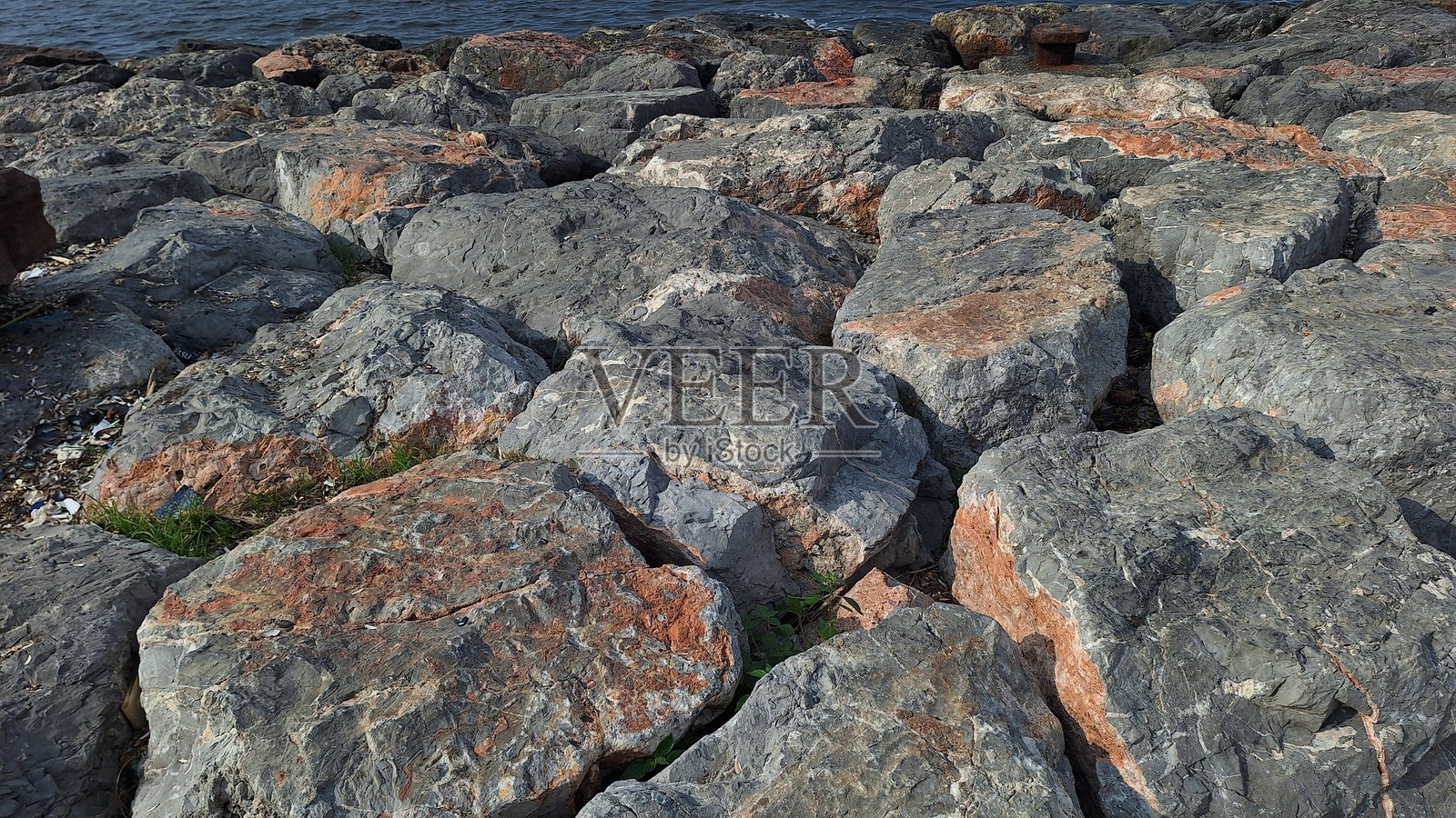 巨大、棱角分明的灰色和锈色岩石照片摄影图片