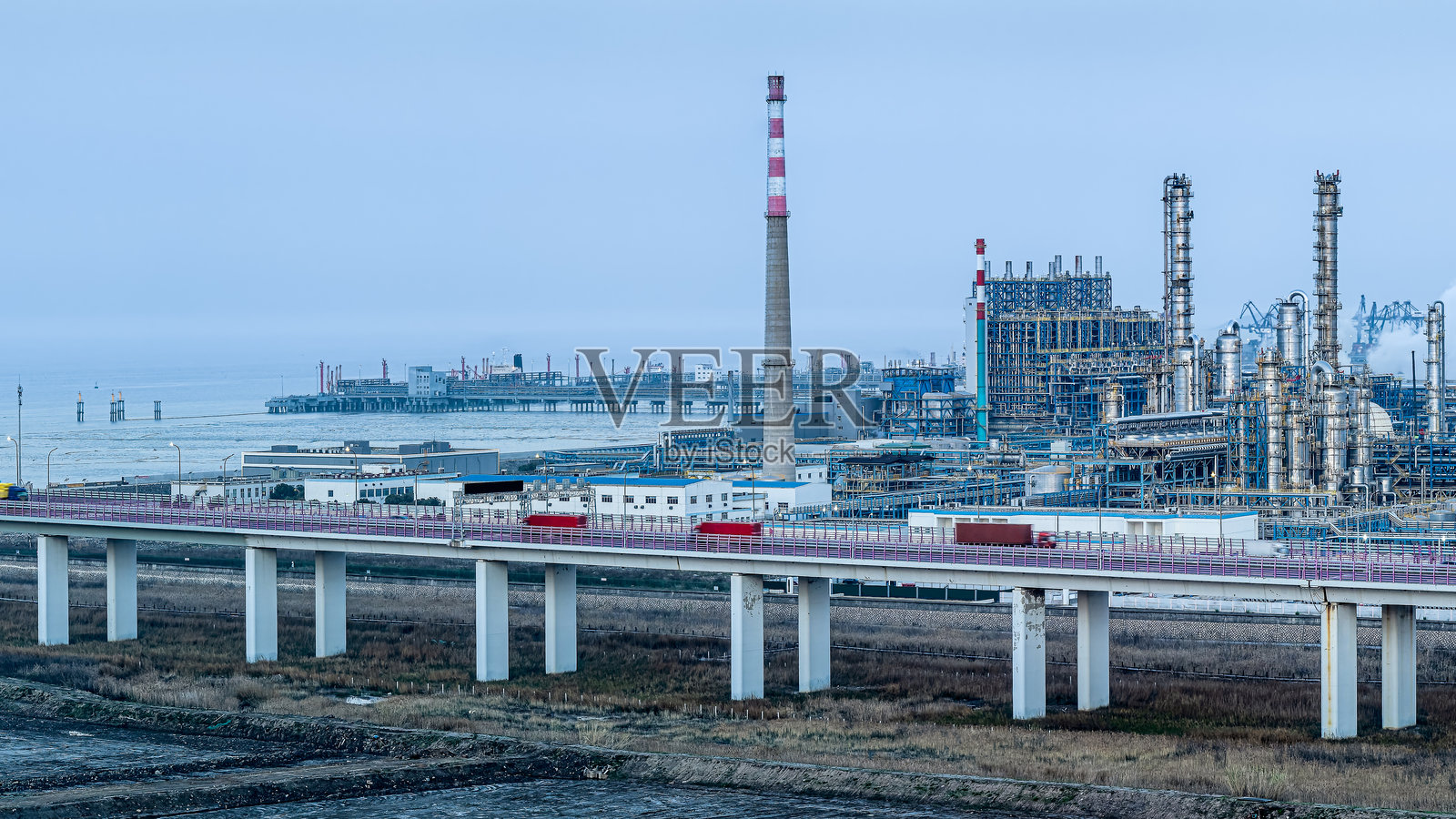 一座桥梁连接着海岸边的炼油厂和石化工业区。照片摄影图片