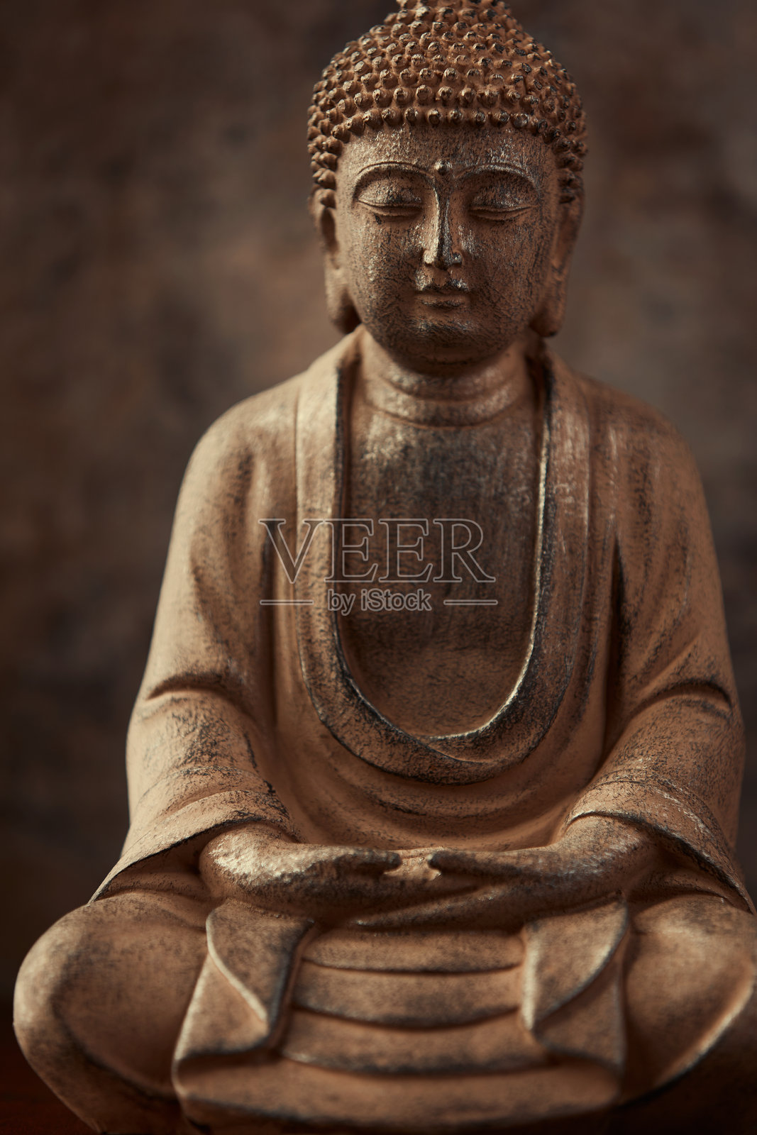 深色背景上的冥想佛像。柔焦。特写。留白。照片摄影图片