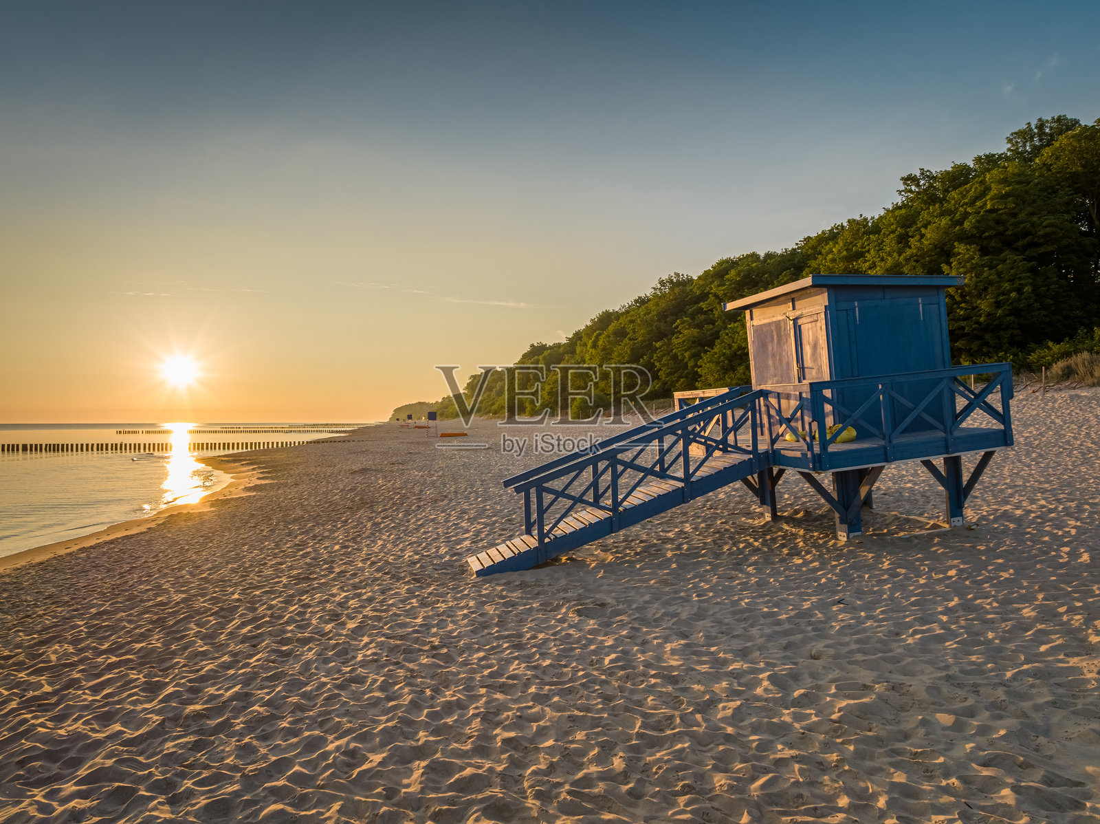 日出时波罗的海海滩上的救生员小屋照片摄影图片