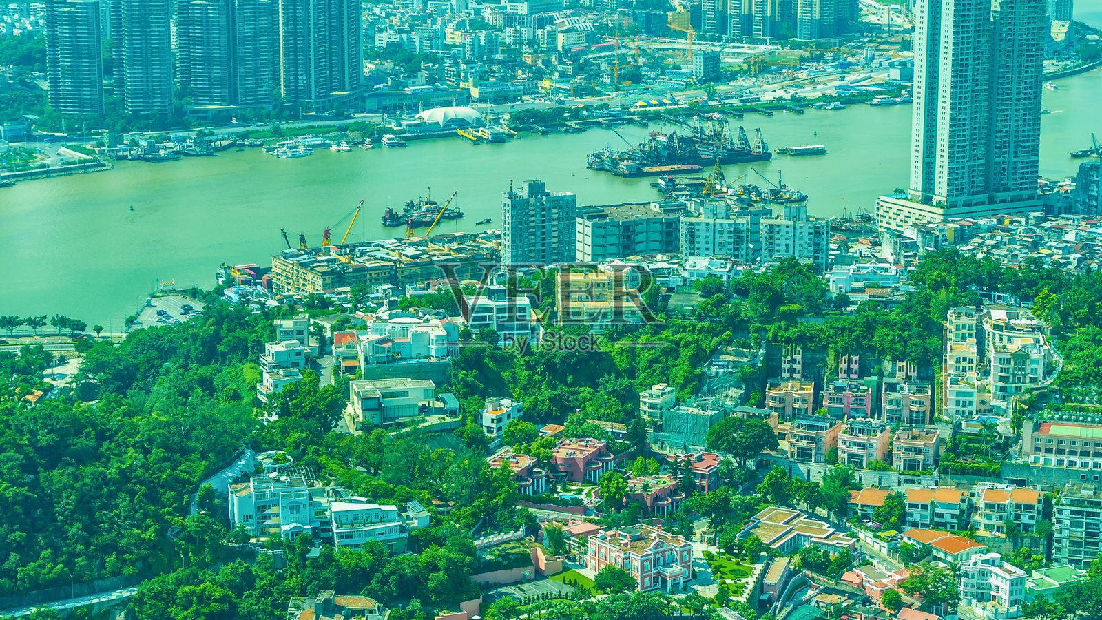 俯瞰郁郁葱葱的绿色城市景观,有河流和建筑照片摄影图片