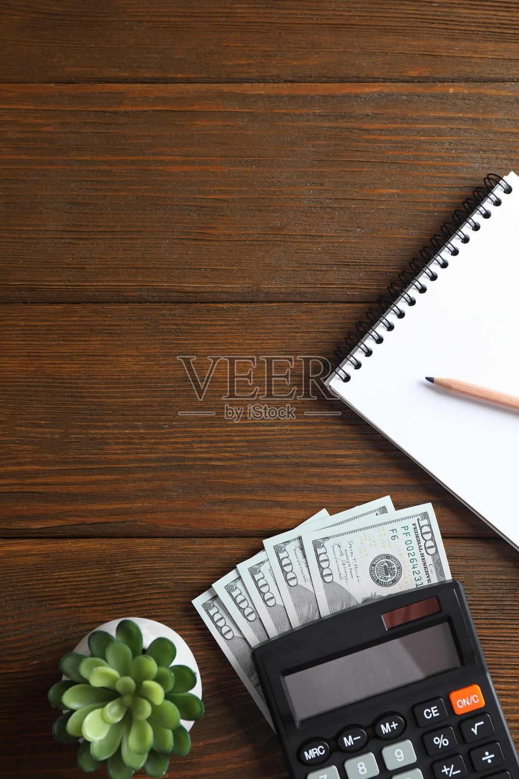 桌上的钱、书籍、计算器和笔记本。照片摄影图片