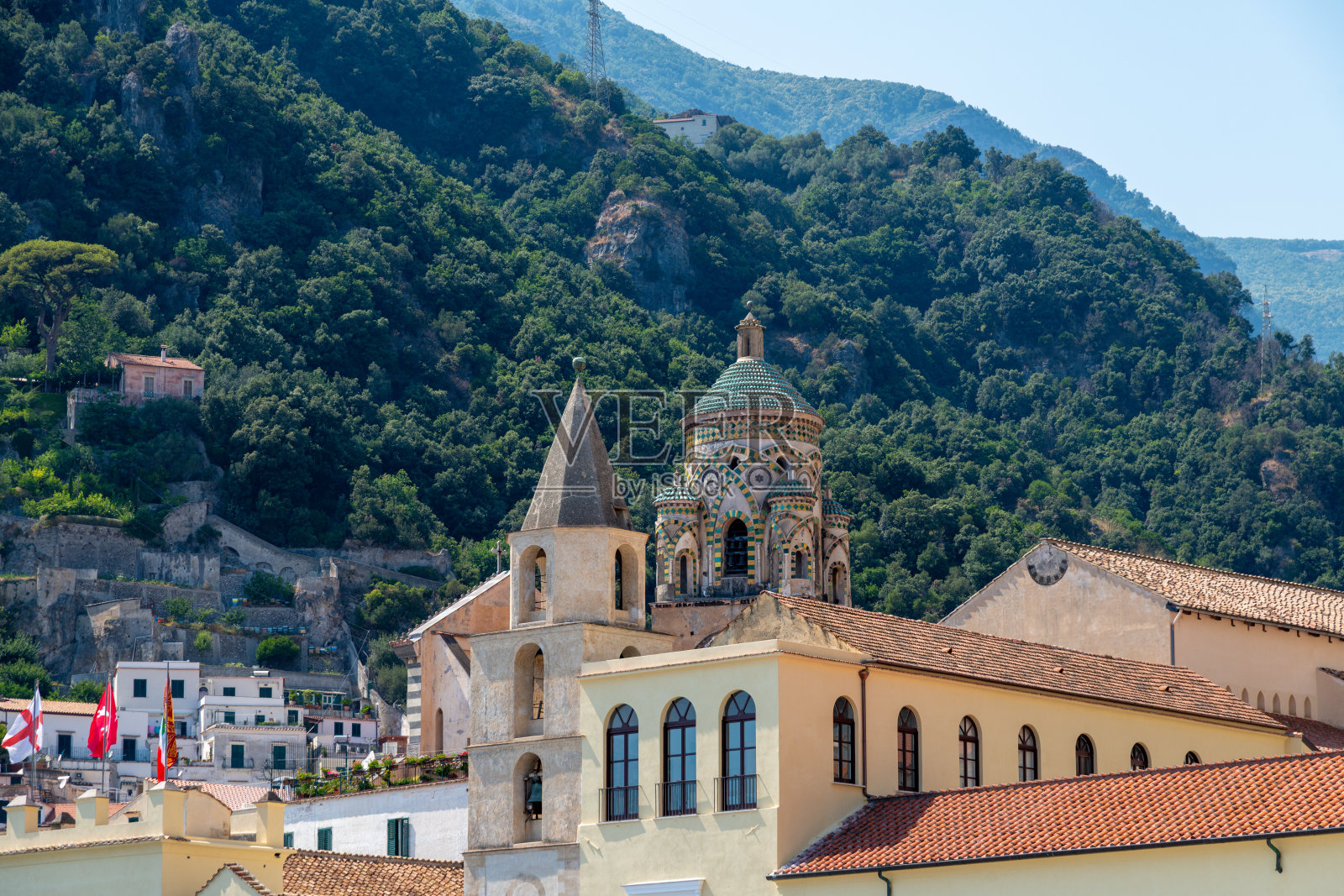身处森林山丘背后的教堂圆顶和钟楼照片摄影图片