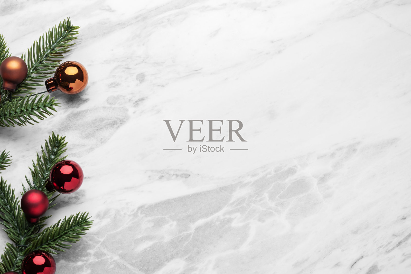 节日圣诞装饰品,松枝与圣诞球装饰在大理石桌面上,俯视角度照片摄影图片