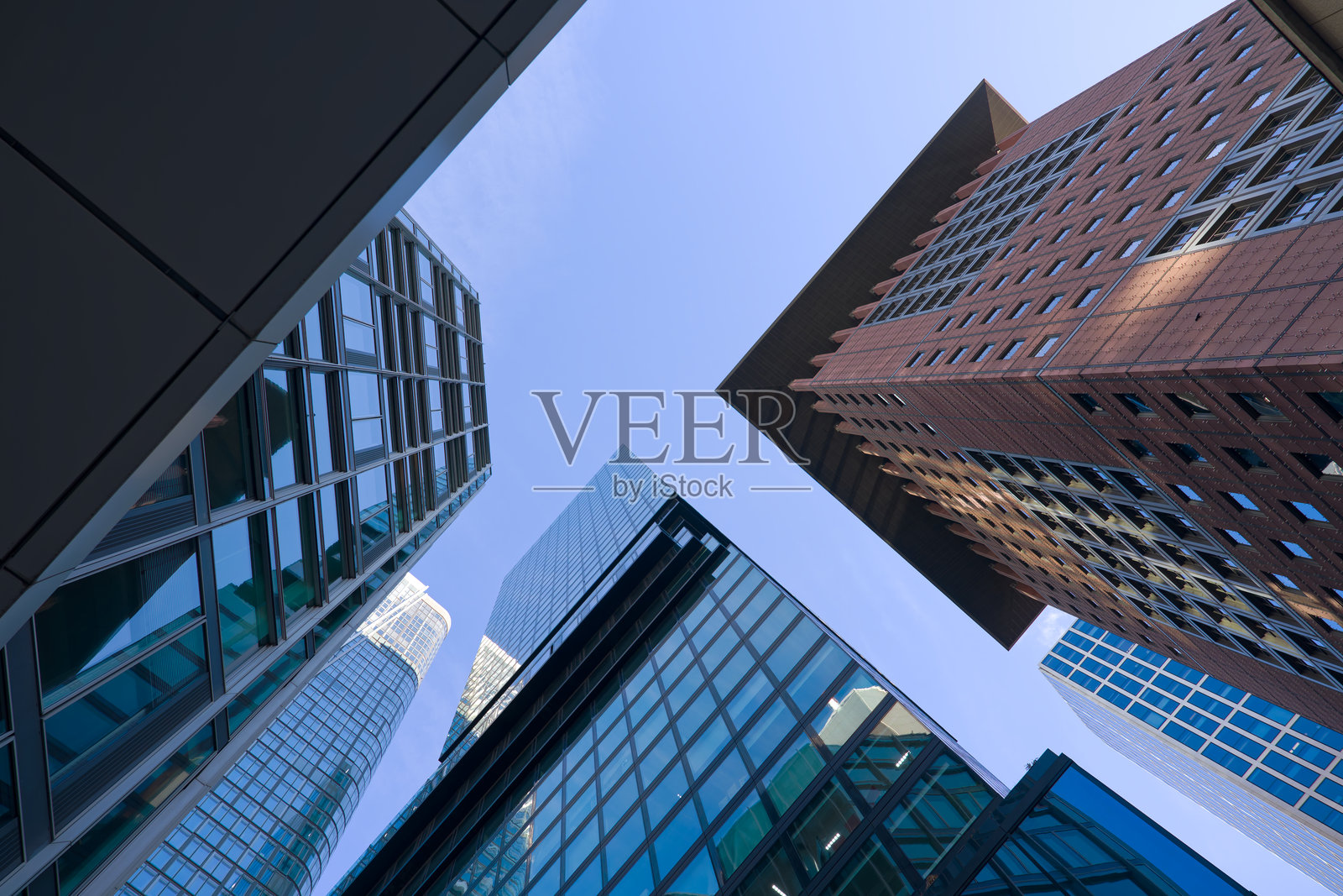 在一个阳光明媚的秋日,抬头仰望德国法兰克福金融区的摩天大楼。照片摄影图片