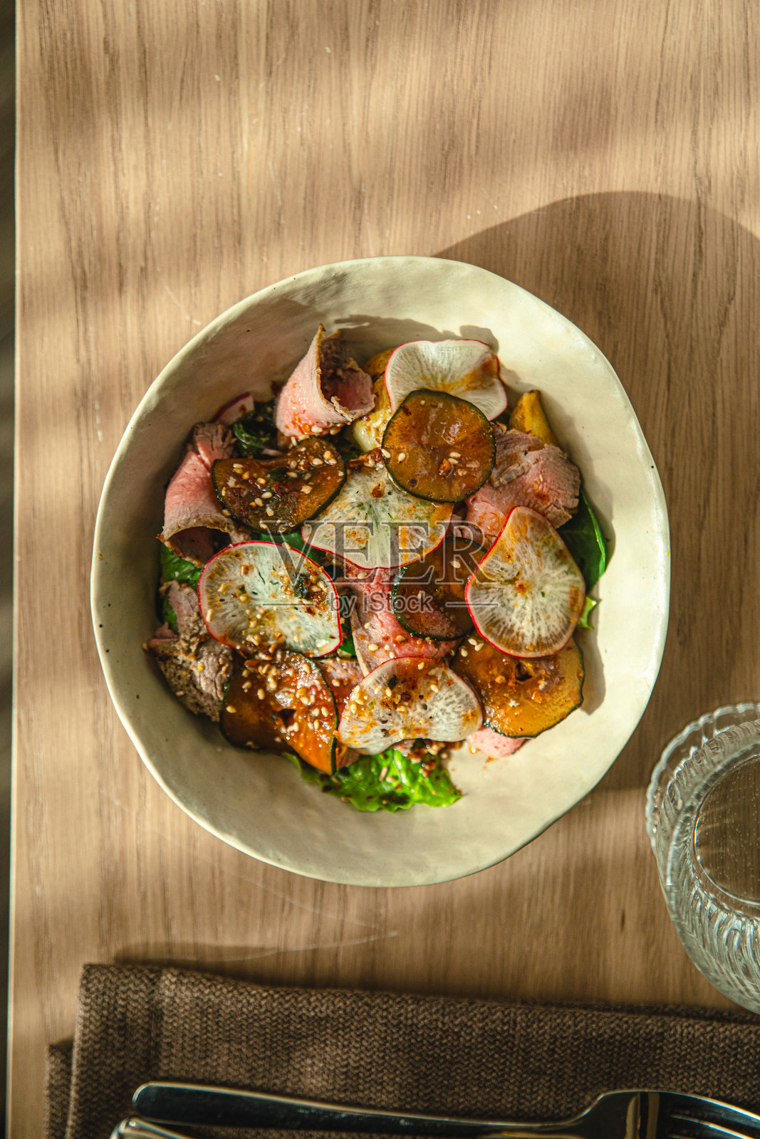 碗装沙拉,有烤牛肉片和萝卜照片摄影图片