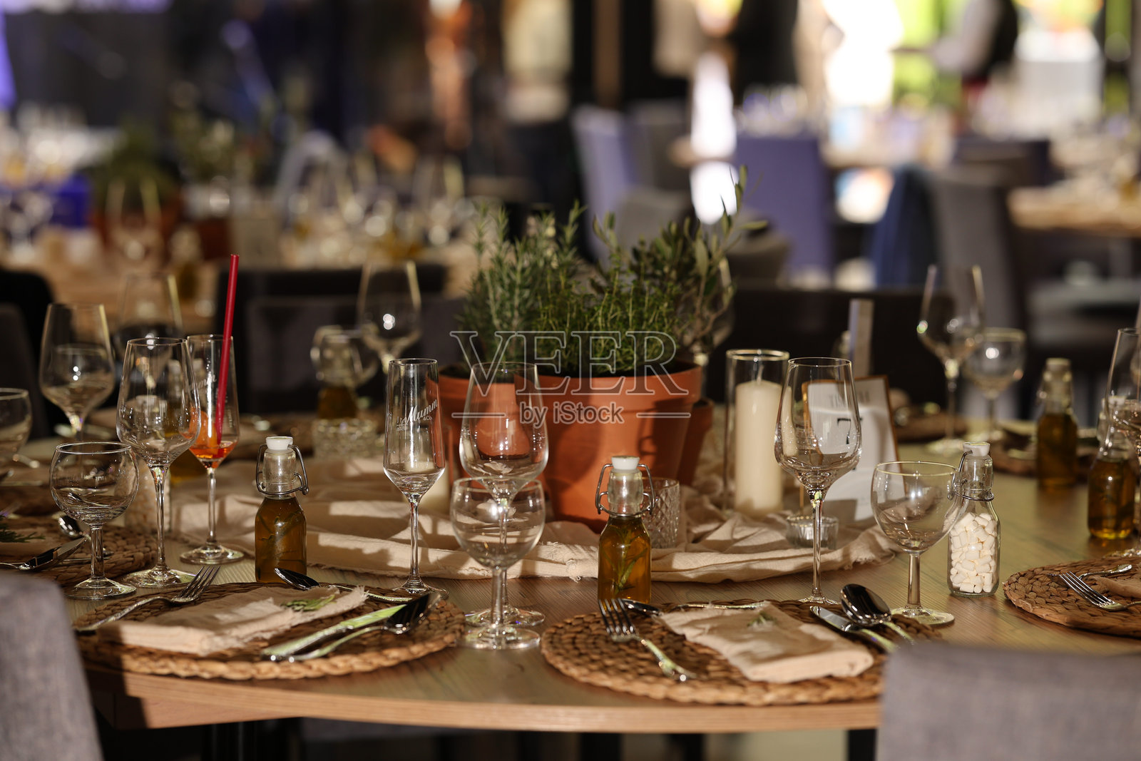 优雅的乡村婚礼餐桌布置,配有香草中心装饰和注入油的伴手礼庆祝活动照片摄影图片