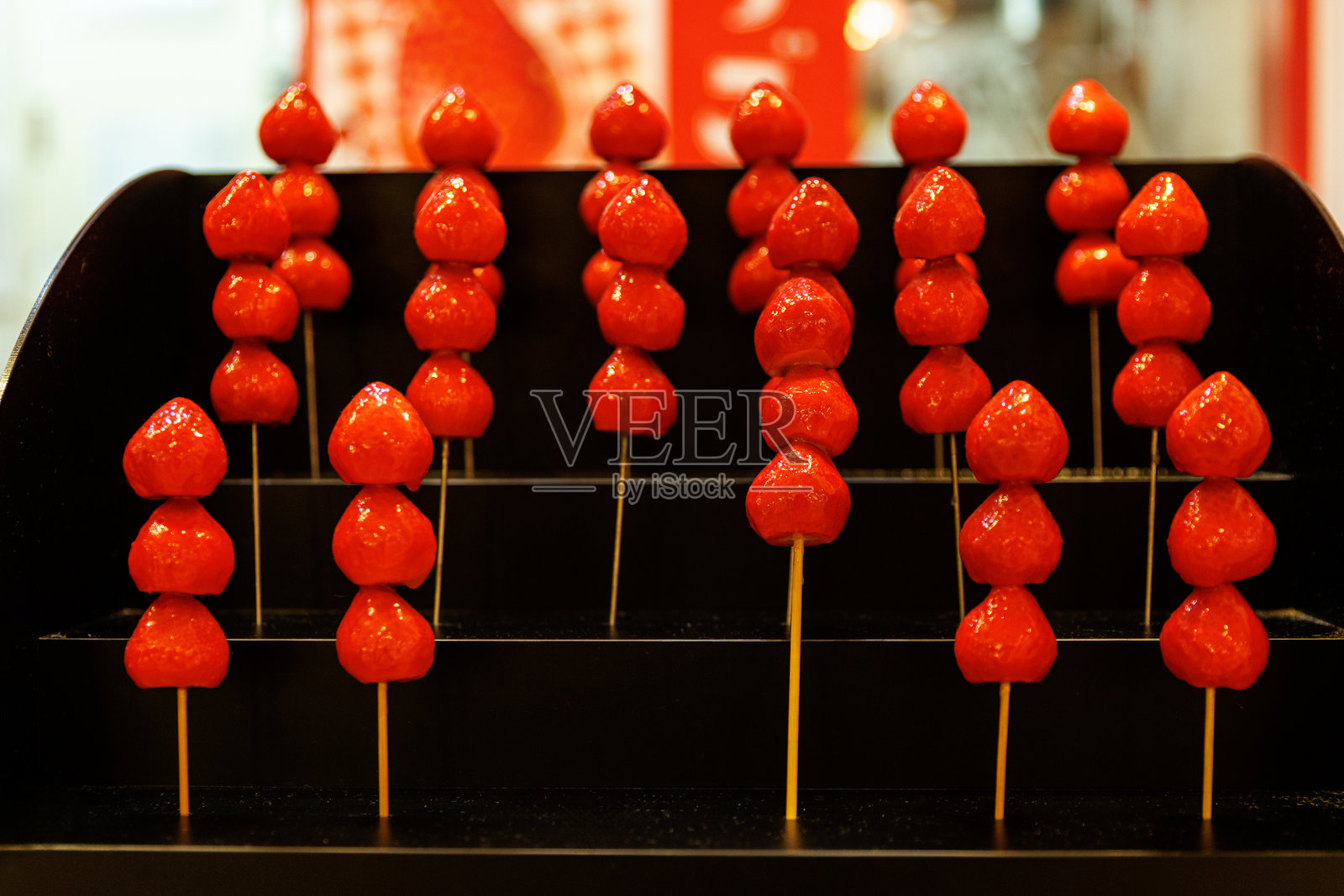 街边小吃摊上展示的糖葫芦草莓串照片摄影图片