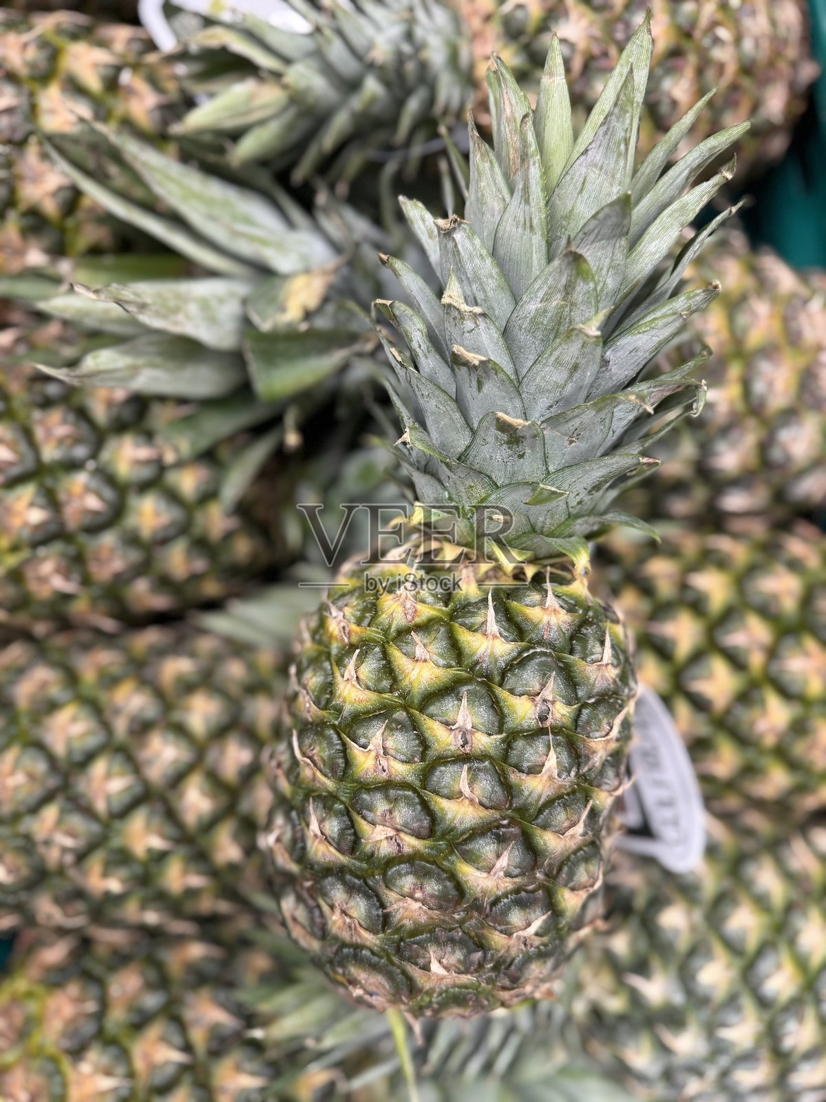 菠萝在杂货摊上等待售卖照片摄影图片