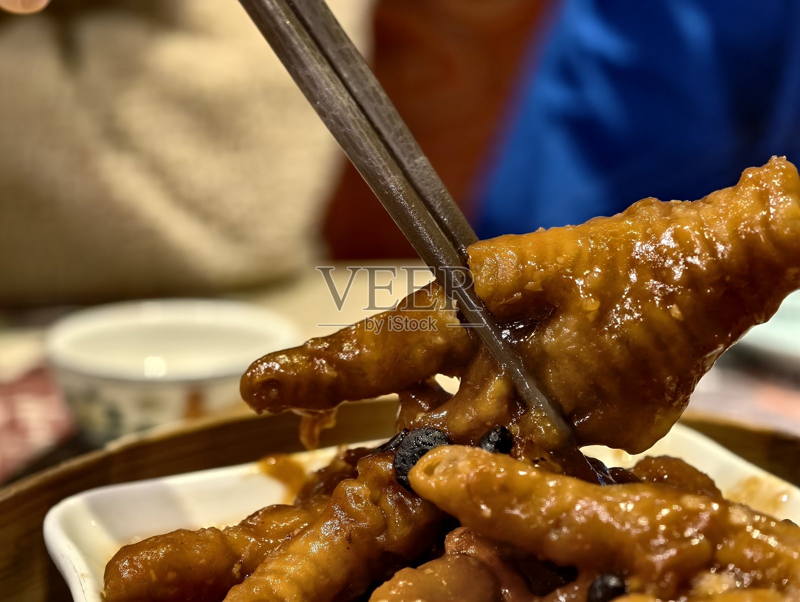 豉汁蒸凤爪,筷子夹取的瞬间照片摄影图片