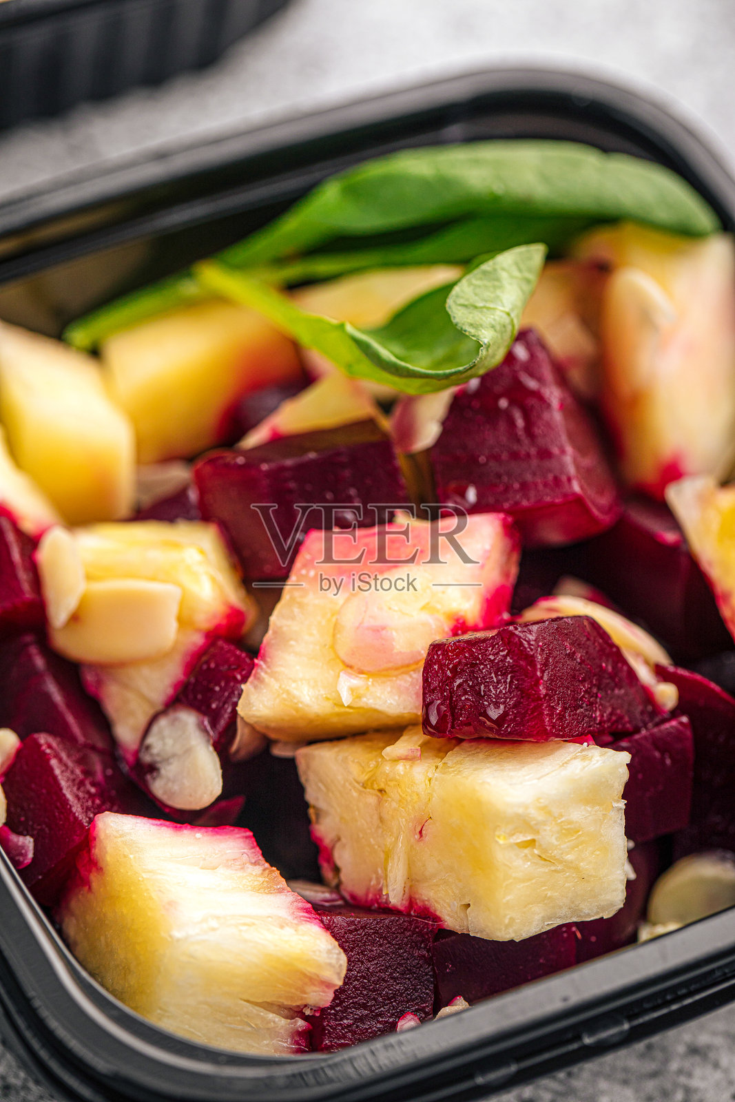 黑色容器中的甜菜根菠萝沙拉照片摄影图片