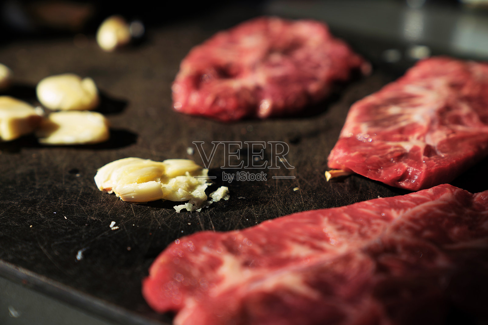 生牛排和捣碎的大蒜照片摄影图片