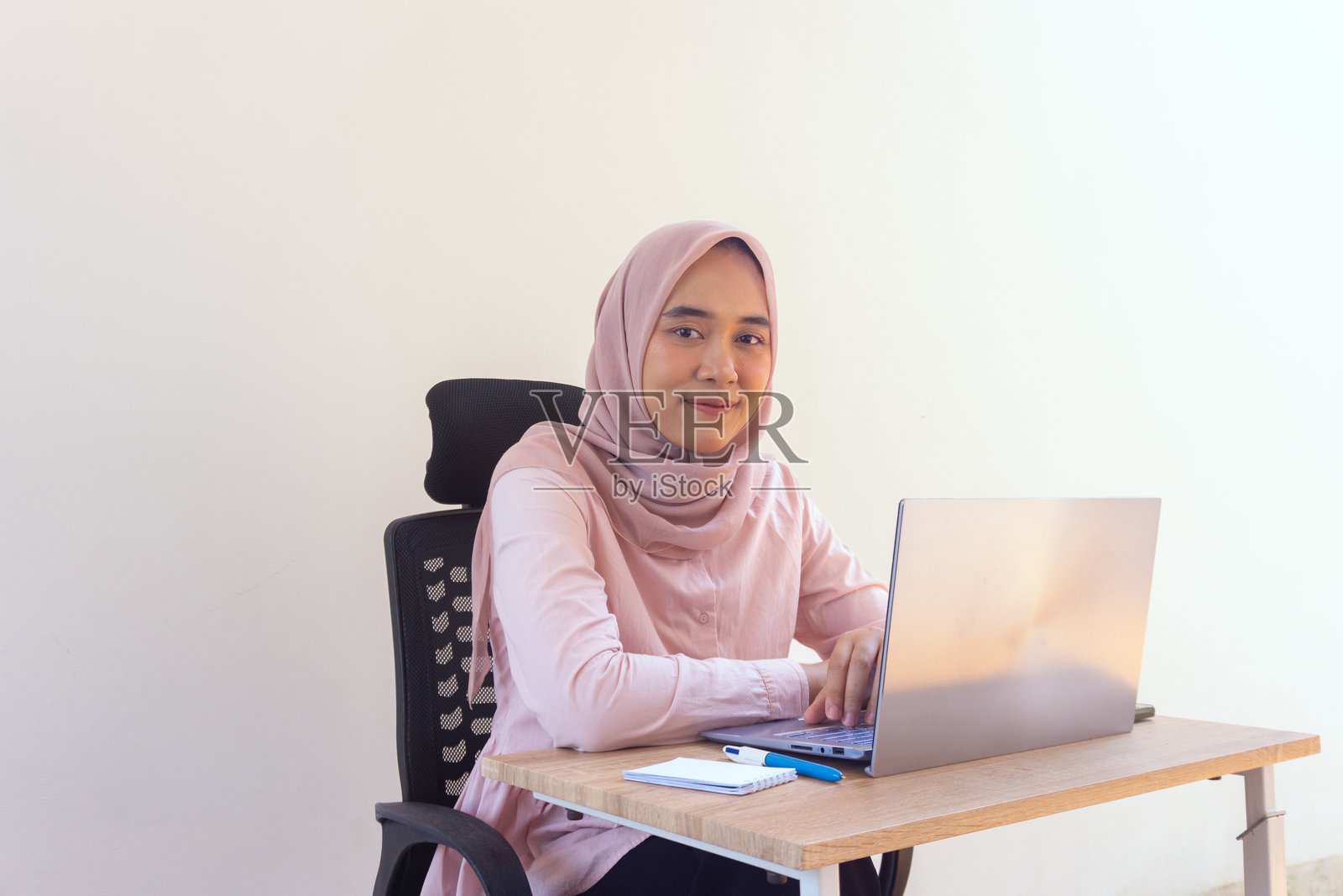 面带微笑的年轻女子在家远程办公,展现成功与幸福照片摄影图片