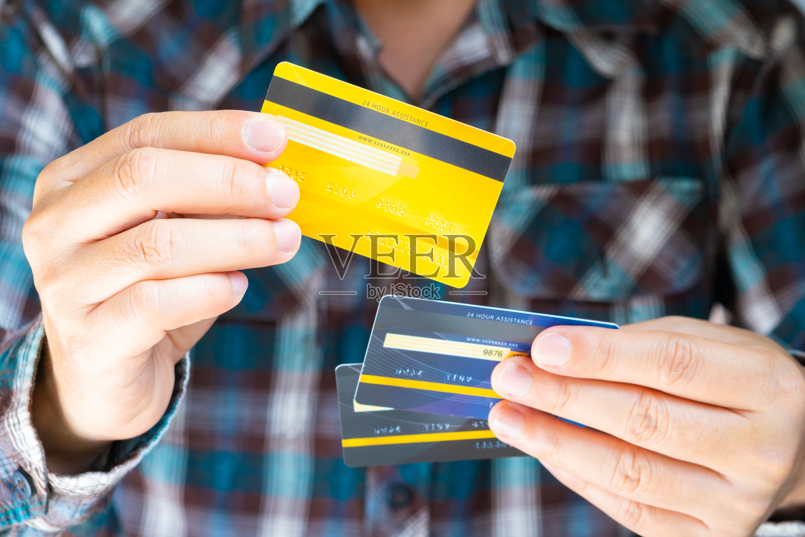 一个人拿着几张信用卡,他正在选择一张信用卡来支付消费。通过信用卡支付商品。金融和银行业务概念。照片摄影图片