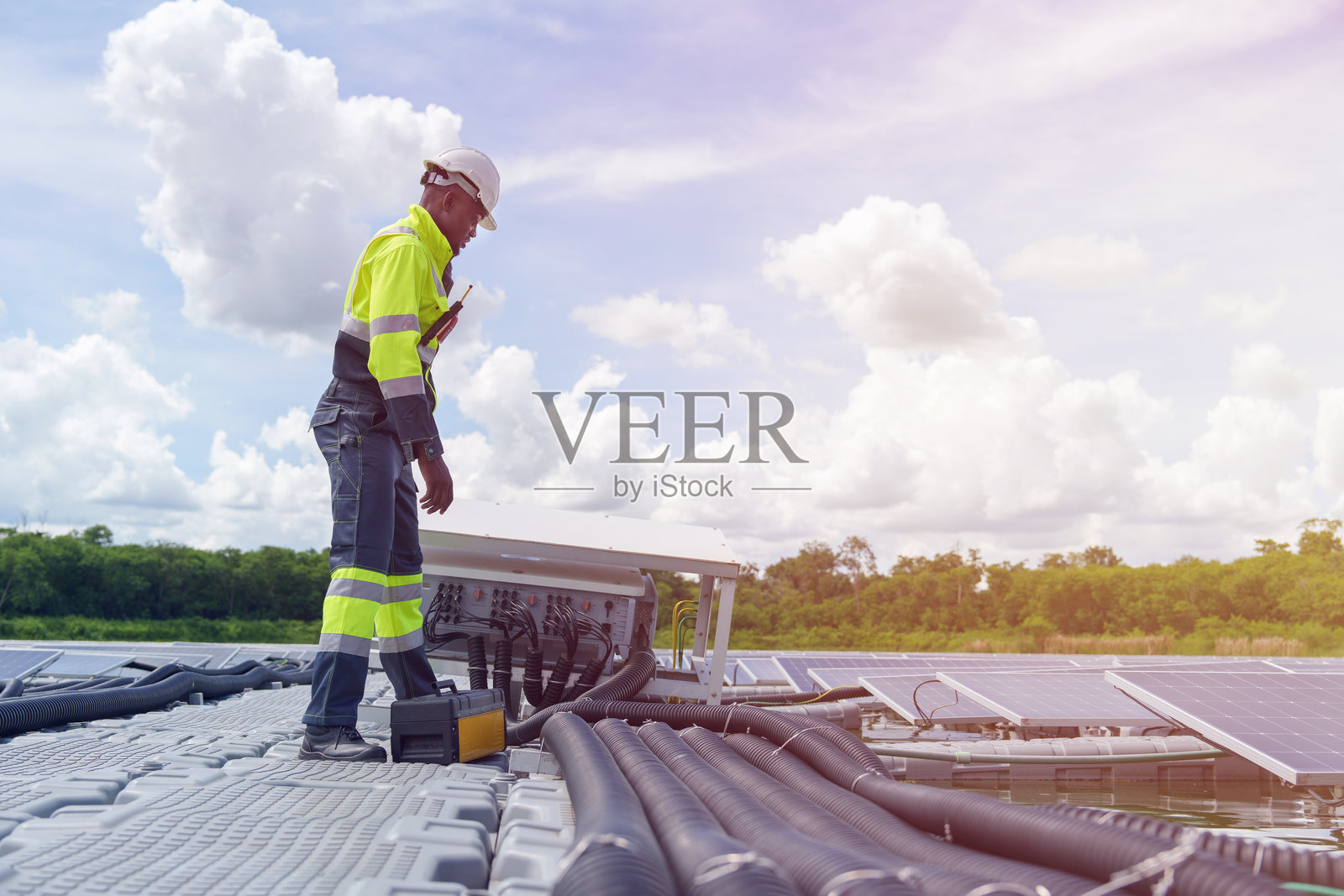 工程师正在检查浮动太阳能发电厂的电气系统。照片摄影图片