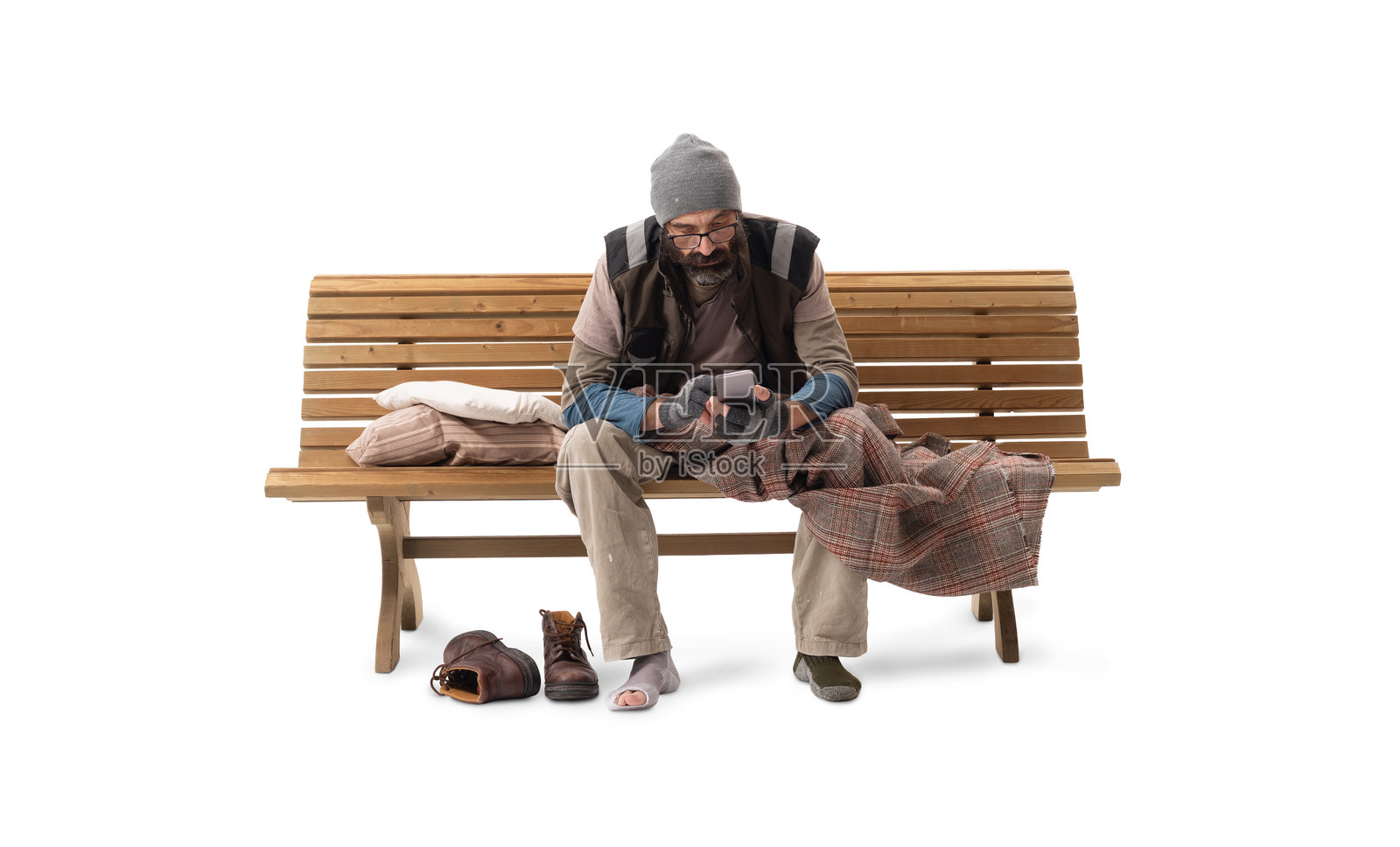 背景为白色的长椅上坐着一位使用智能手机的无家可归的男人照片摄影图片