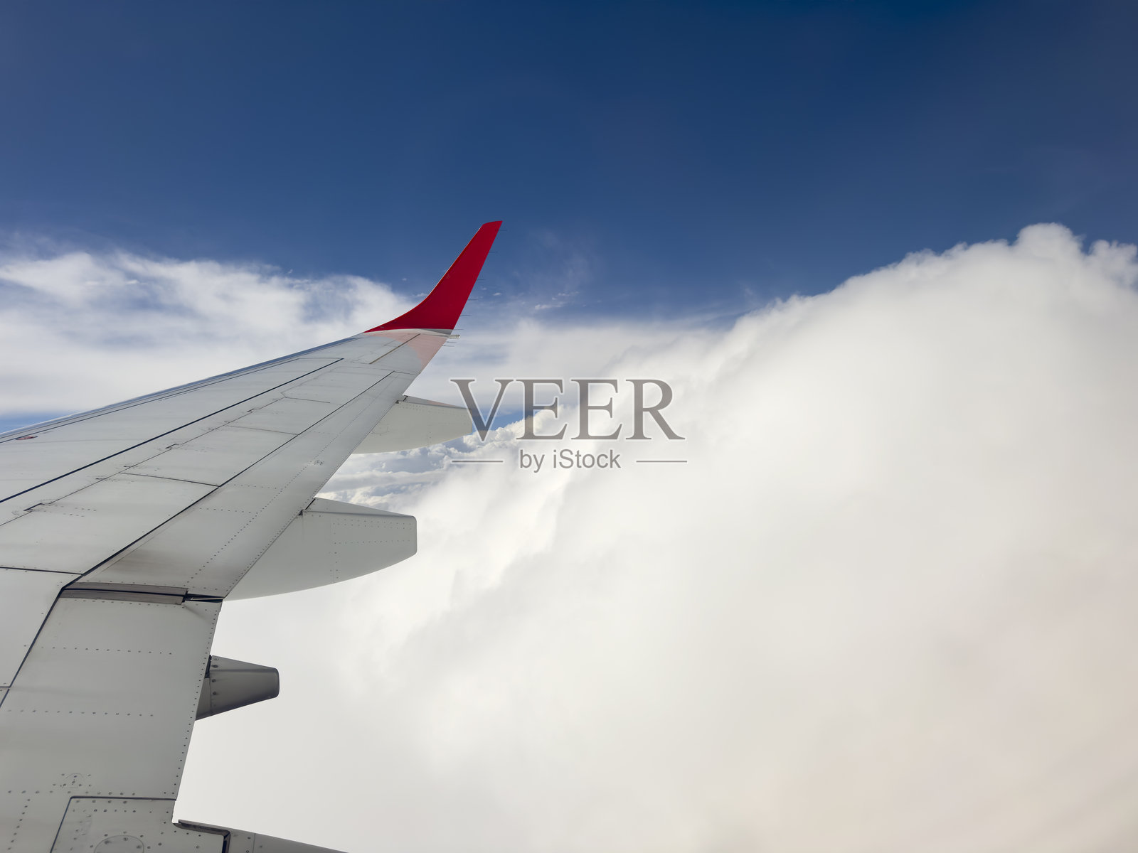 飞机机翼掠过广阔的积云,背景是蓝天照片摄影图片