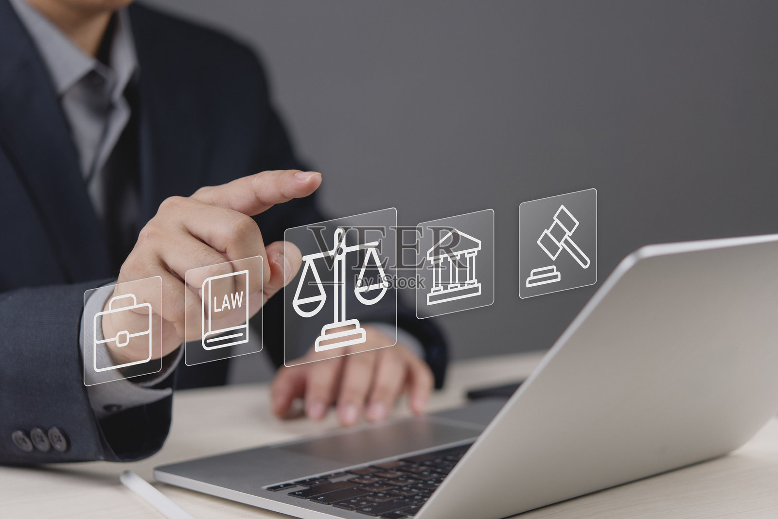商人的手在虚拟屏幕上触摸法律公正天平图标。律师使用笔记本电脑提供法律咨询服务,注重科技理念。数字法庭、互联网监管、合规、权利体系及权威。照片摄影图片