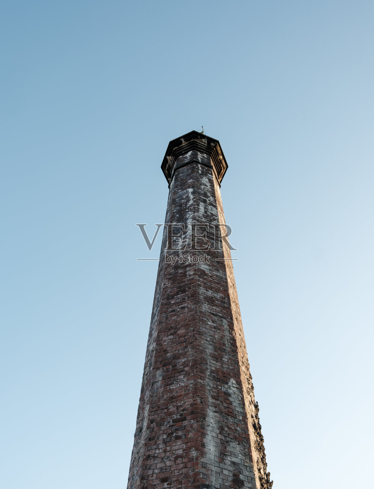 高耸的砖砌烟囱,背景是晴朗的蓝天照片摄影图片