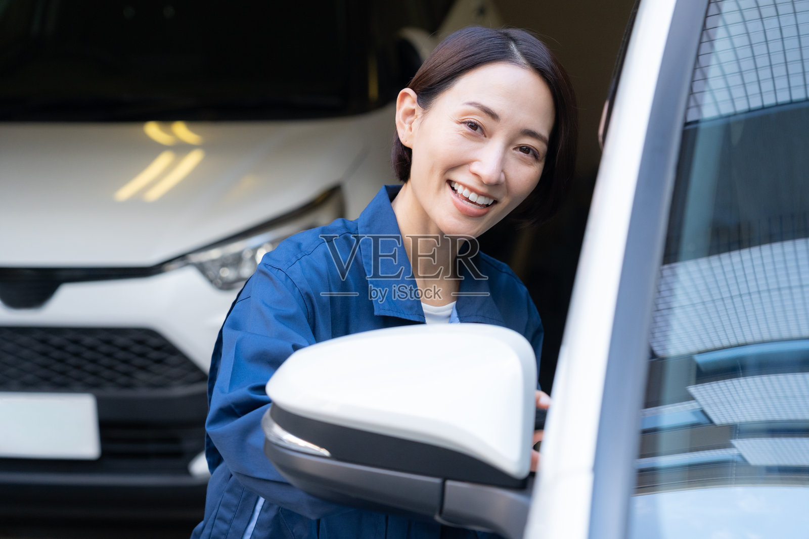 中年女汽车修理工正在修理汽车照片摄影图片