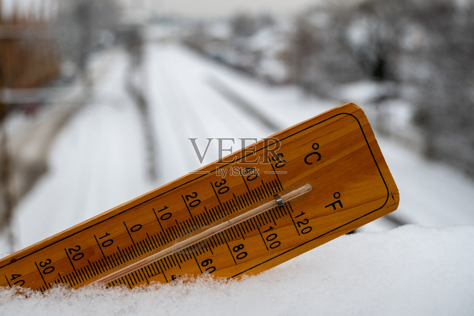 木制温度计在雪景中测量冰点温度照片摄影图片