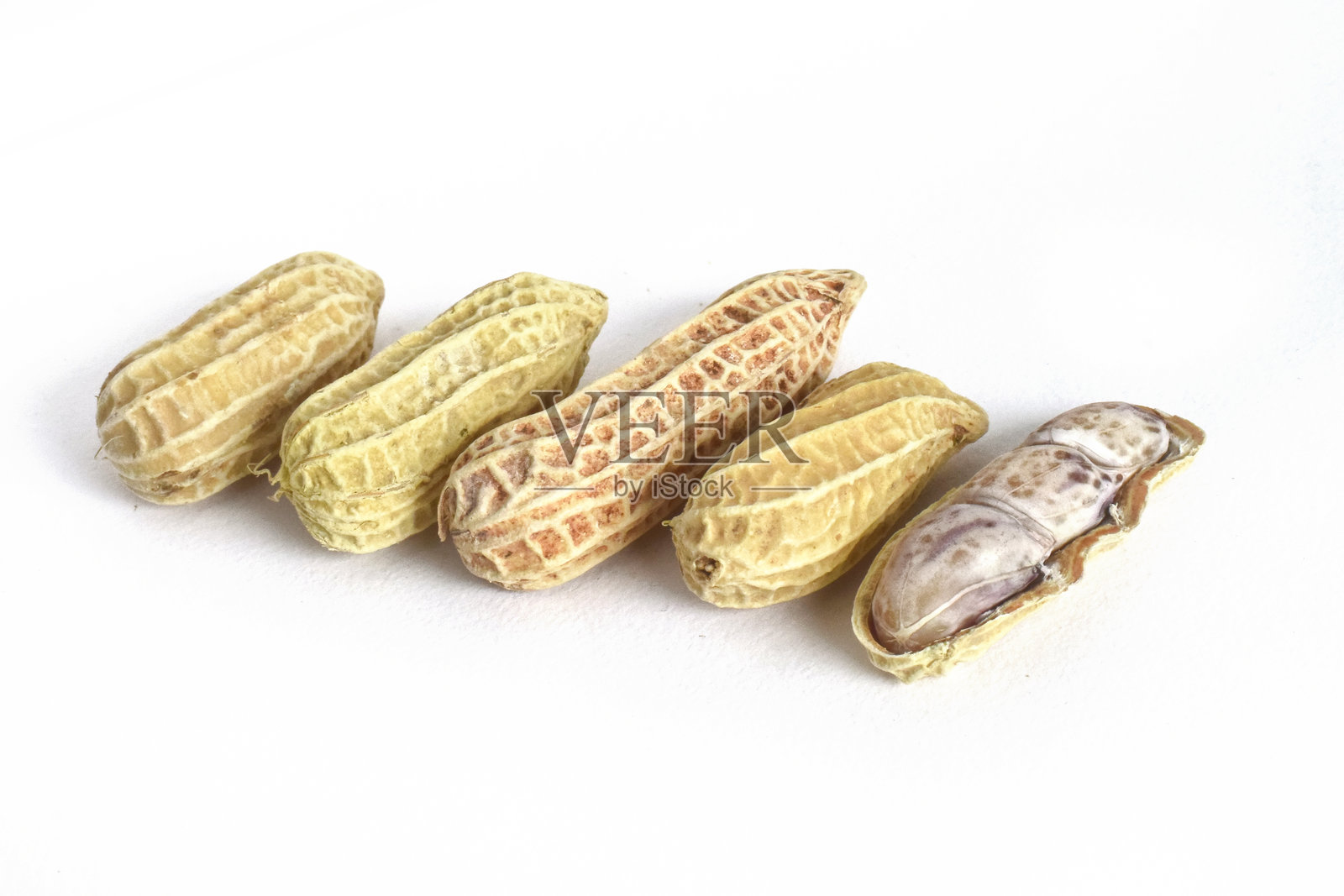 煮花生,剥开花生壳露出花生仁,摆放在白色背景上。照片摄影图片