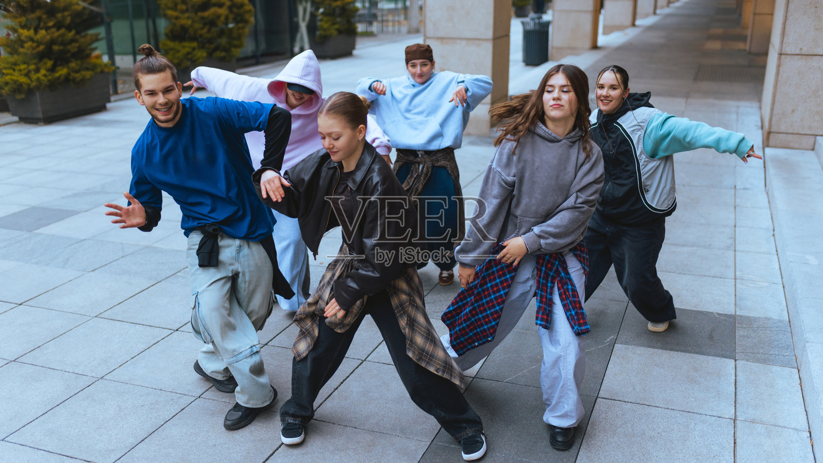 一群舞者在开阔的城市空间里同步律动。照片摄影图片