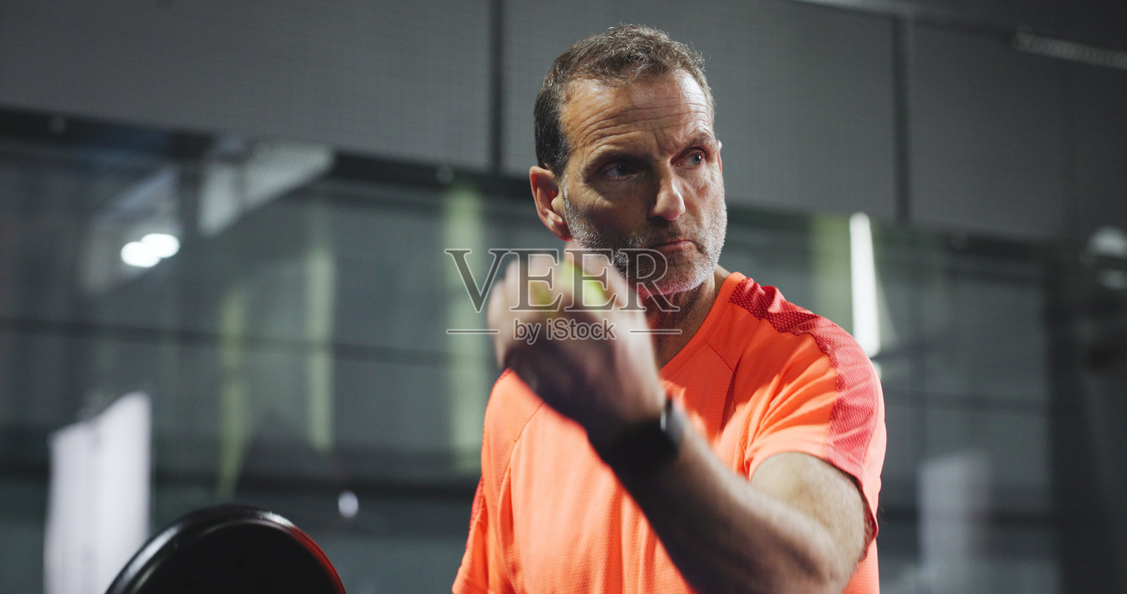 一名男子在球场上进行板式网球运动,进行锻炼、训练和比赛俱乐部活动。这位成熟的运动员在草地上进行比赛练习、锻炼和挑战,为比赛、体育竞技和开局做准备。照片摄影图片