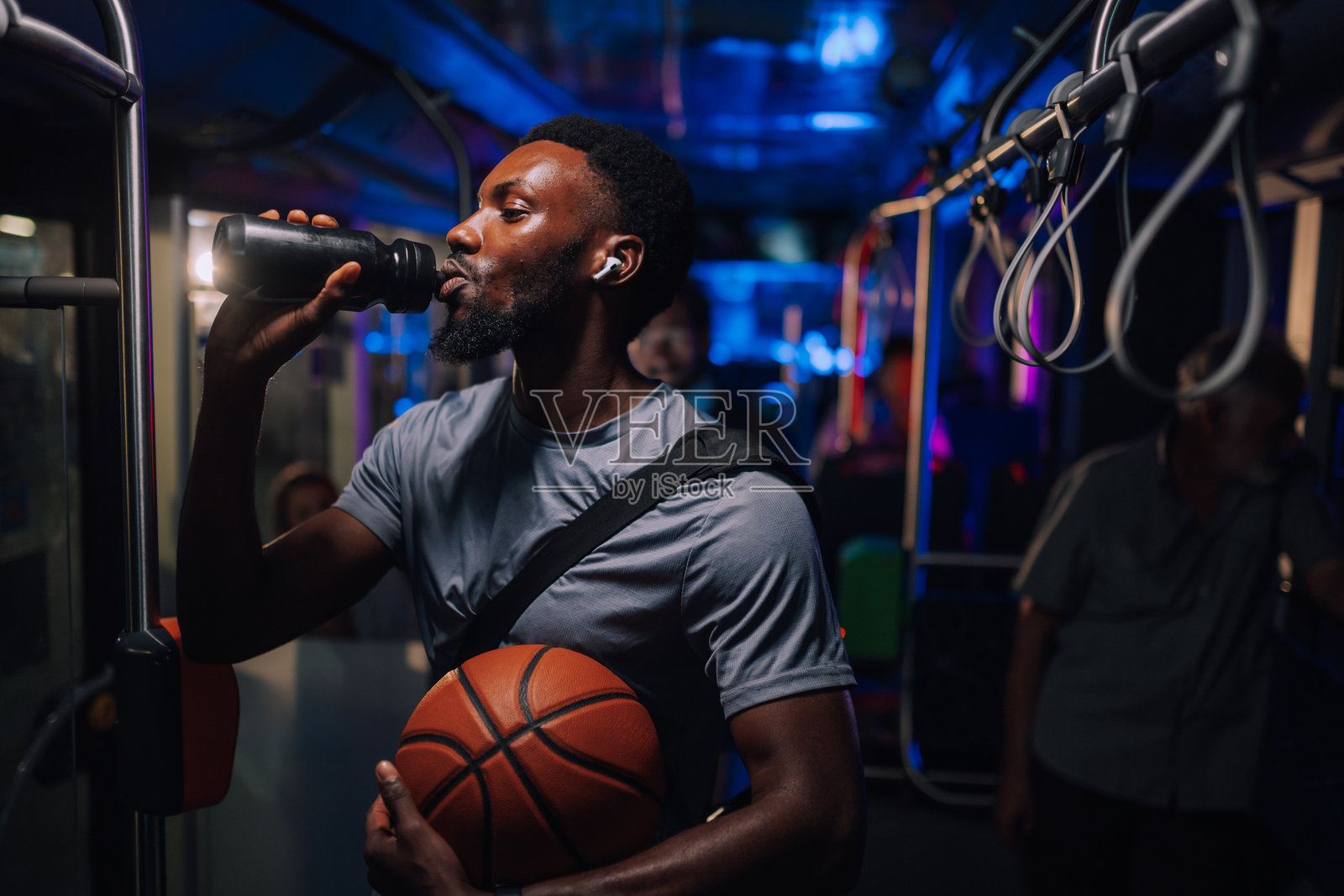 夜间,一名篮球运动员在公交车上补充水分照片摄影图片