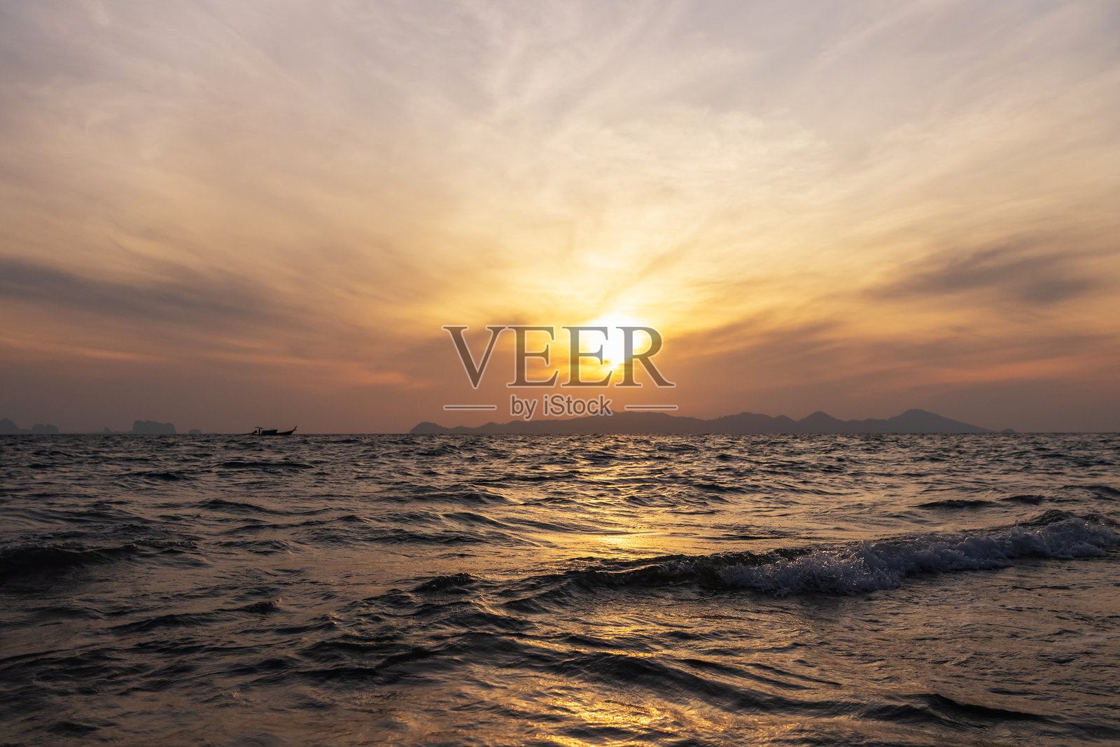 夕阳下的海平面,金色的波浪倒映着天空的云彩照片摄影图片