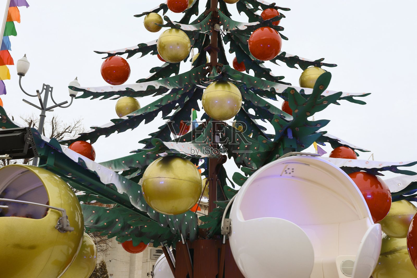 节日景点——圣诞树,以球形贡多拉为装饰,在有装饰品和旗帜的冬季地点。照片摄影图片