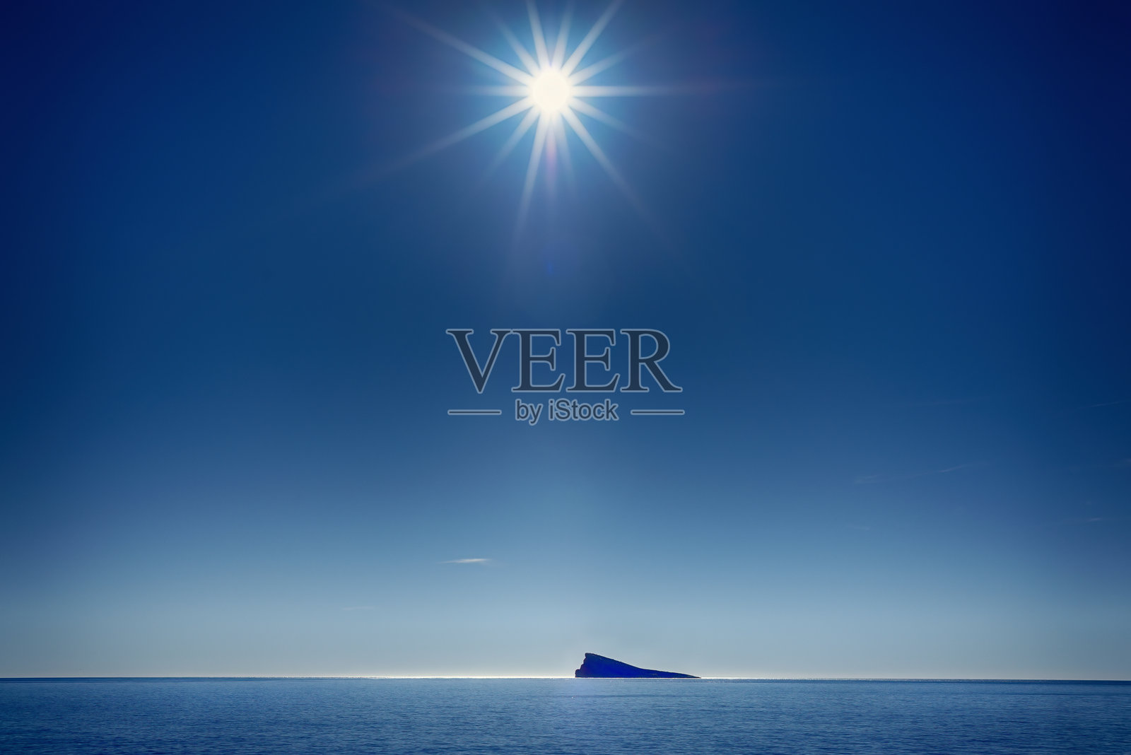 西班牙贝尼多姆市著名岛屿上方的阳光和湛蓝的天空照片摄影图片