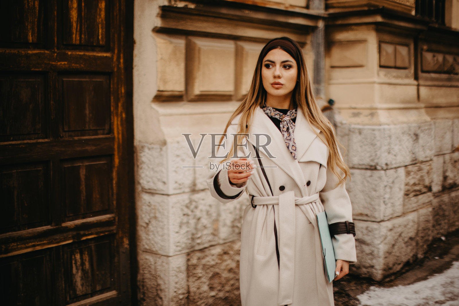 身穿风衣的女子在城市街道上携带文件夹照片摄影图片