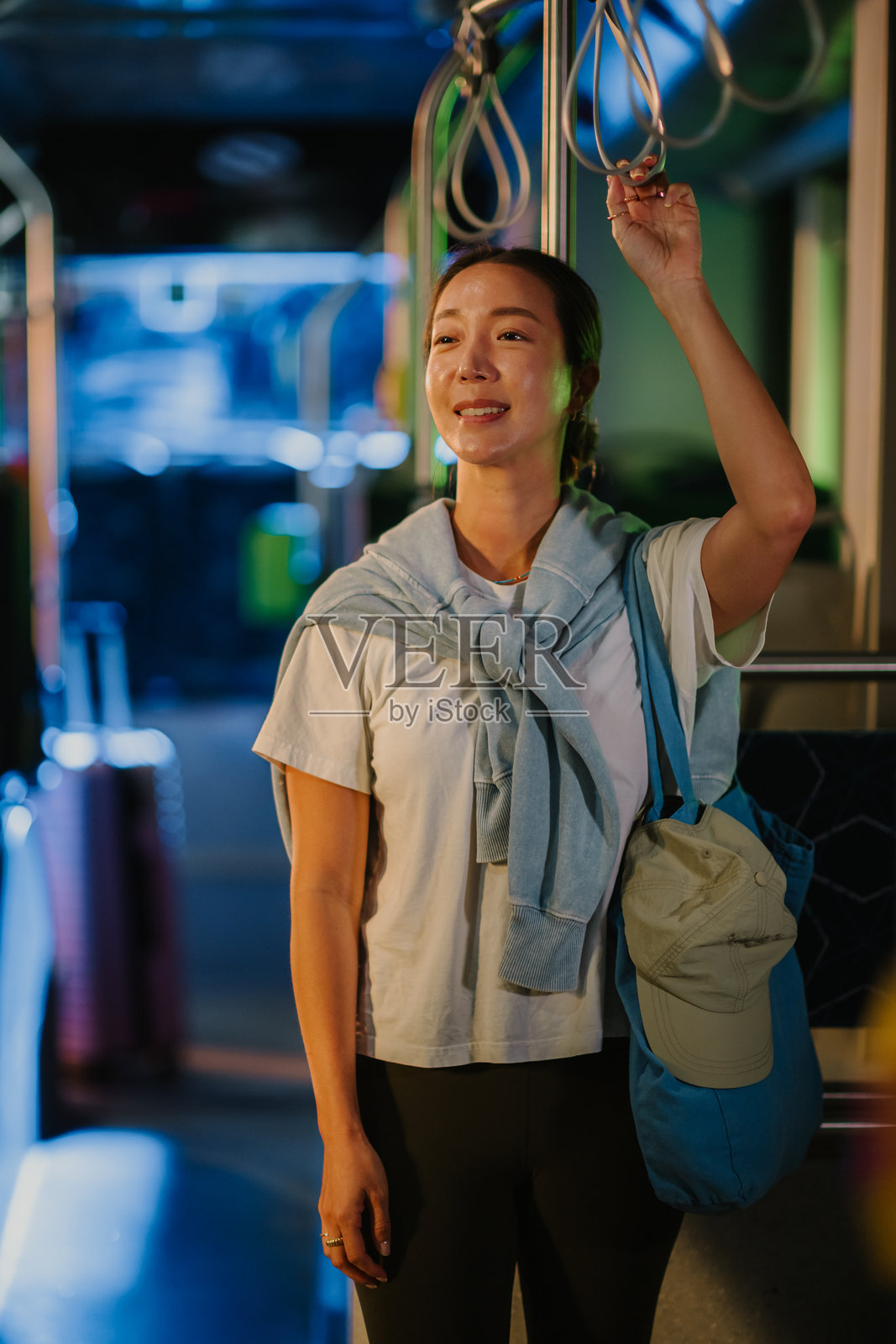 女子夜间乘公交通勤,面带微笑照片摄影图片