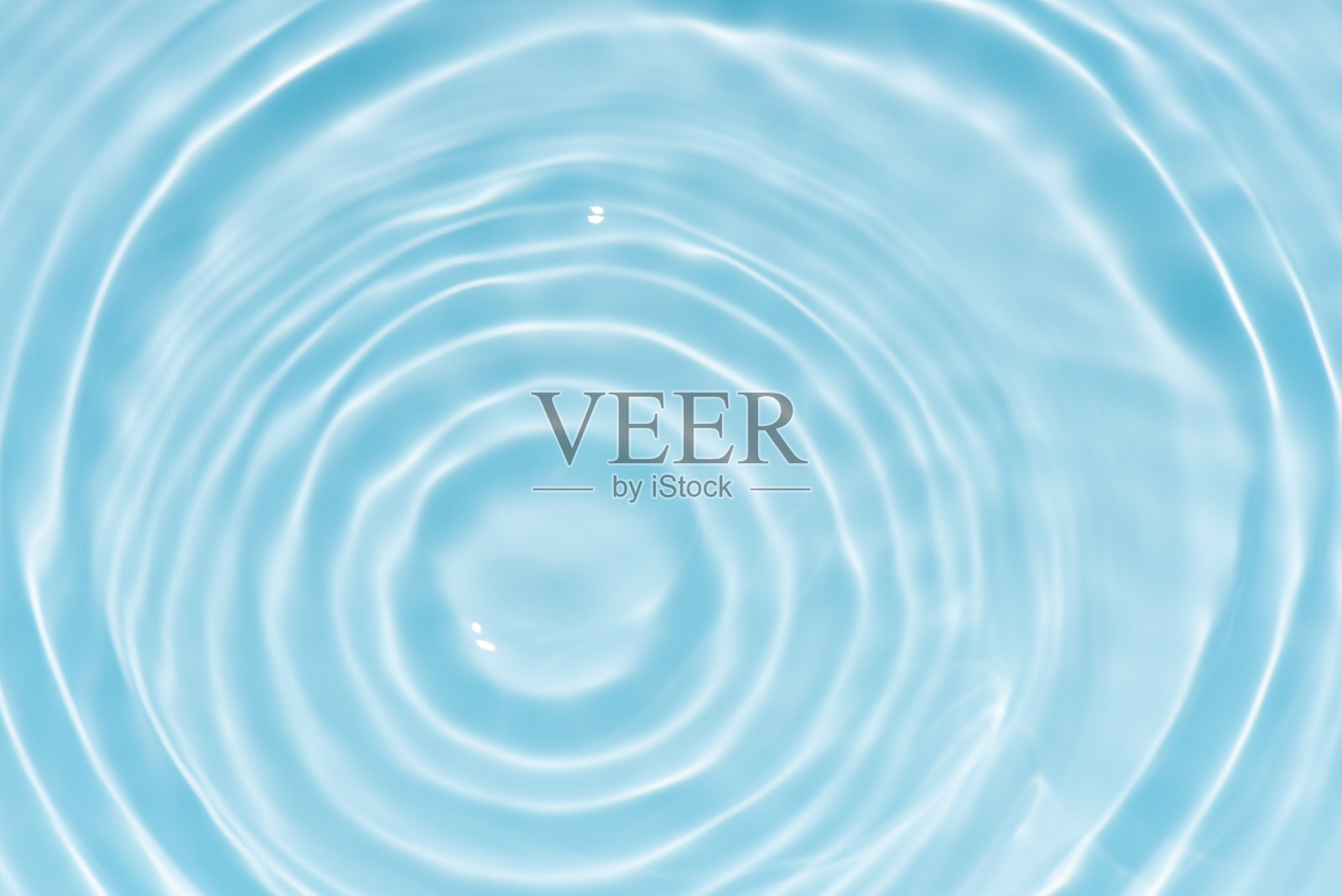 蓝色水面有涟漪。失焦模糊的透明蓝色清澈平静水面纹理,带有飞溅和气泡。水波带有闪亮图案纹理背景。照片摄影图片