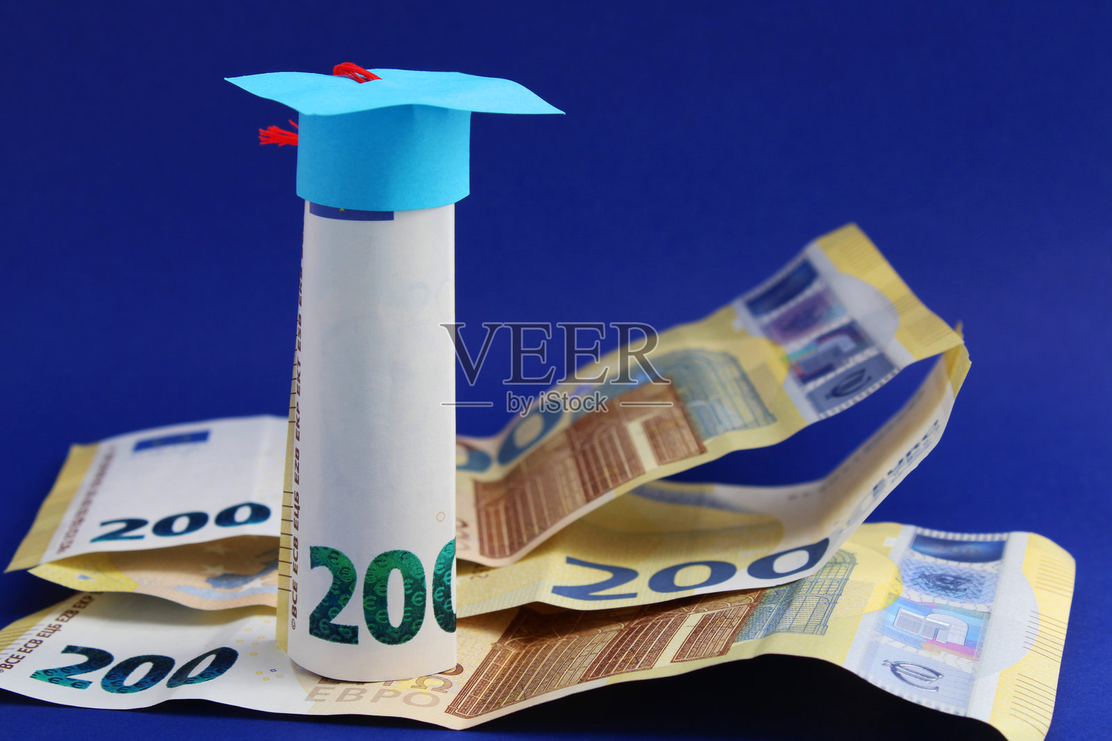 毕业帽放在两百欧元纸币上,教育成本照片摄影图片
