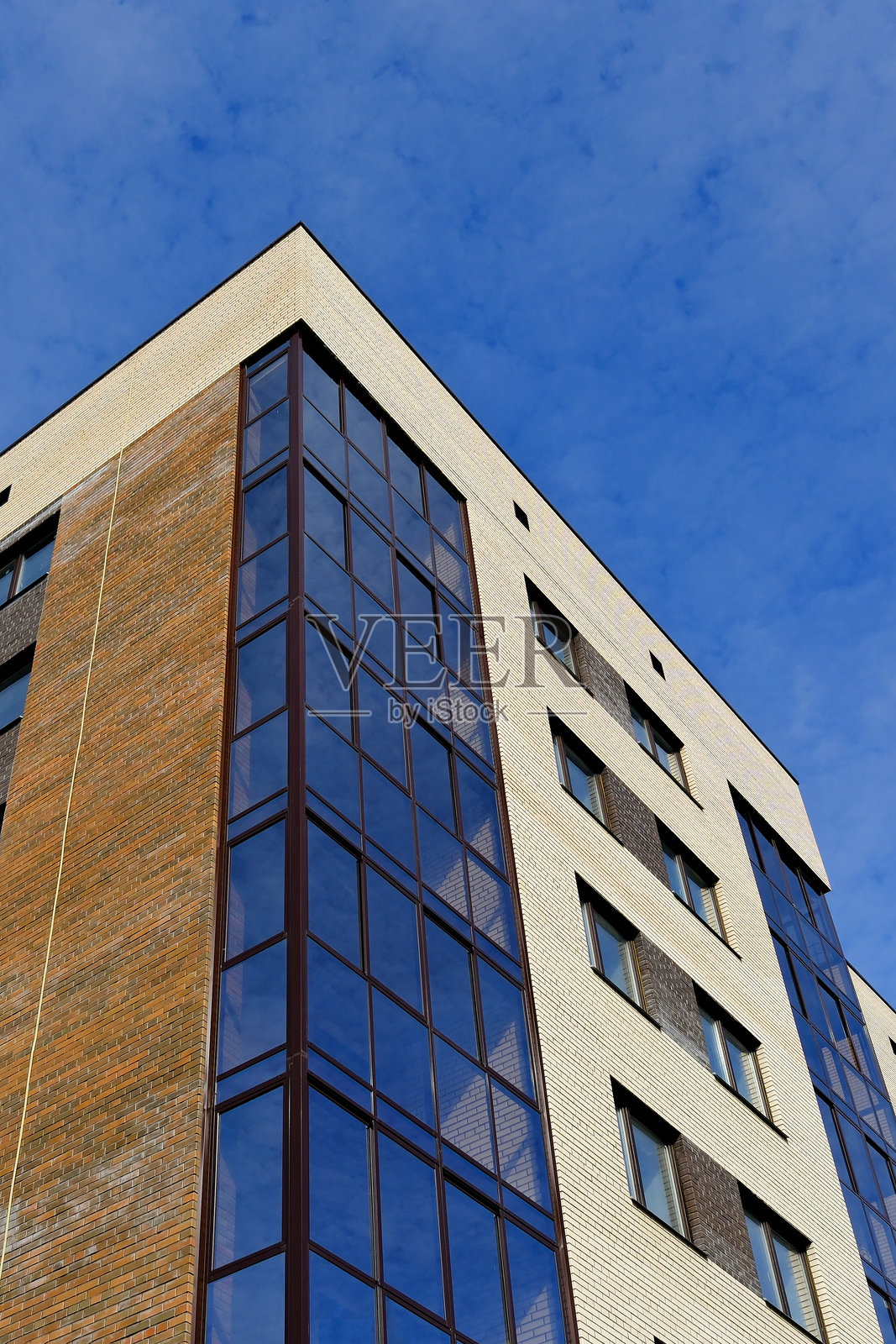 现代建筑外观,玻璃与砖块构成,背景为天空。照片摄影图片