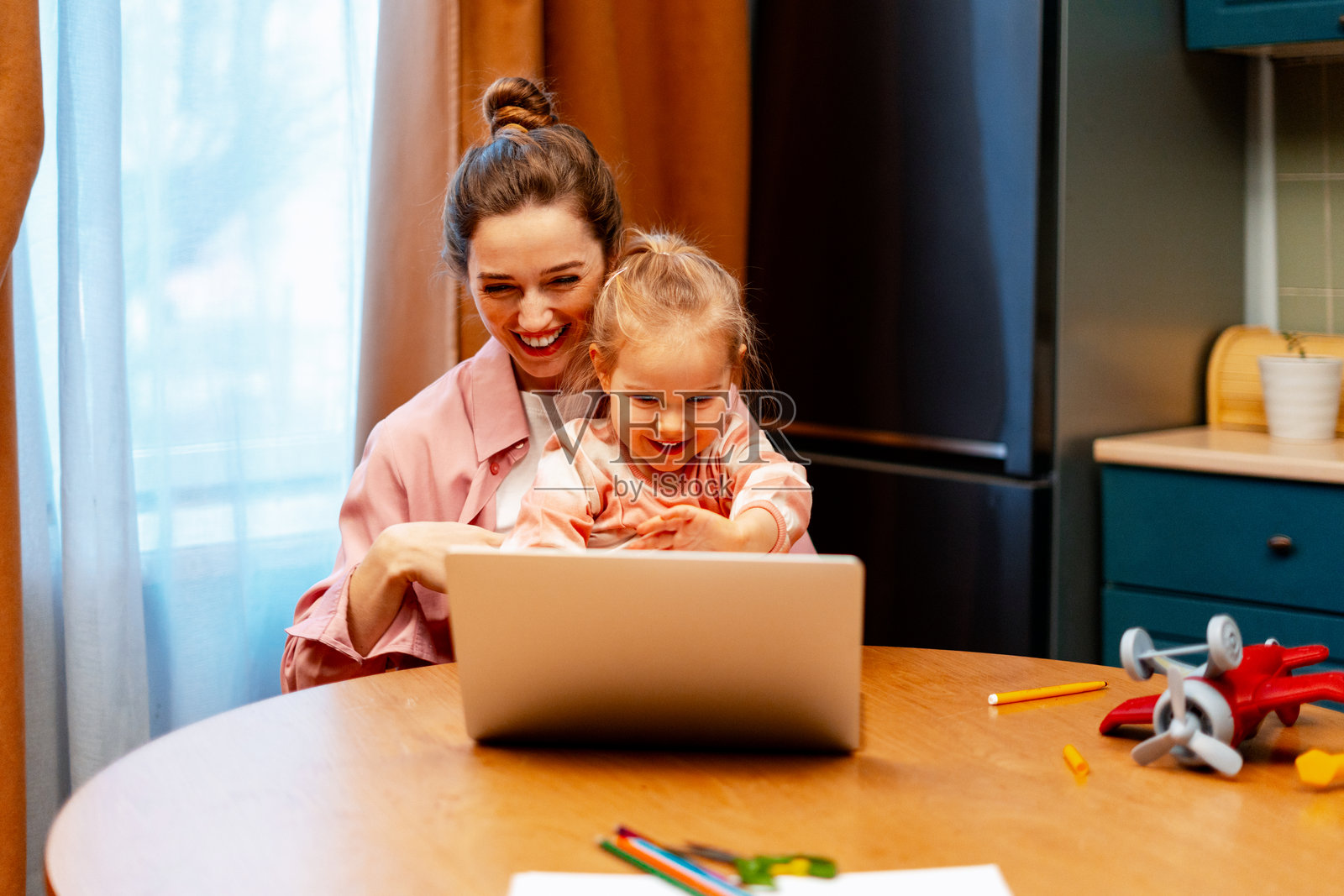 妈妈和女儿在家一起看着笔记本电脑屏幕,分享着快乐的时光照片摄影图片
