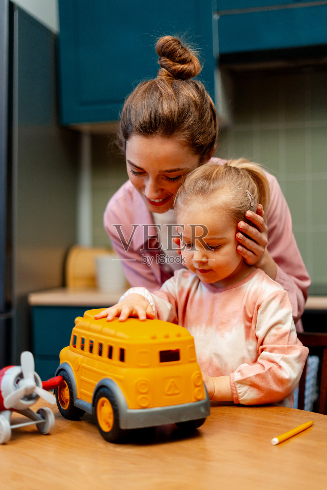 妈妈和孩子在家玩玩具巴士,享受特别的家庭时光照片摄影图片