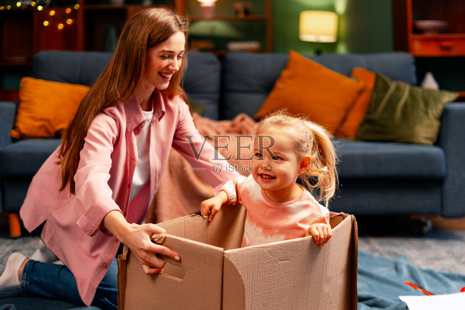 妈妈和女儿在客厅玩纸箱,享受童年的乐趣照片摄影图片