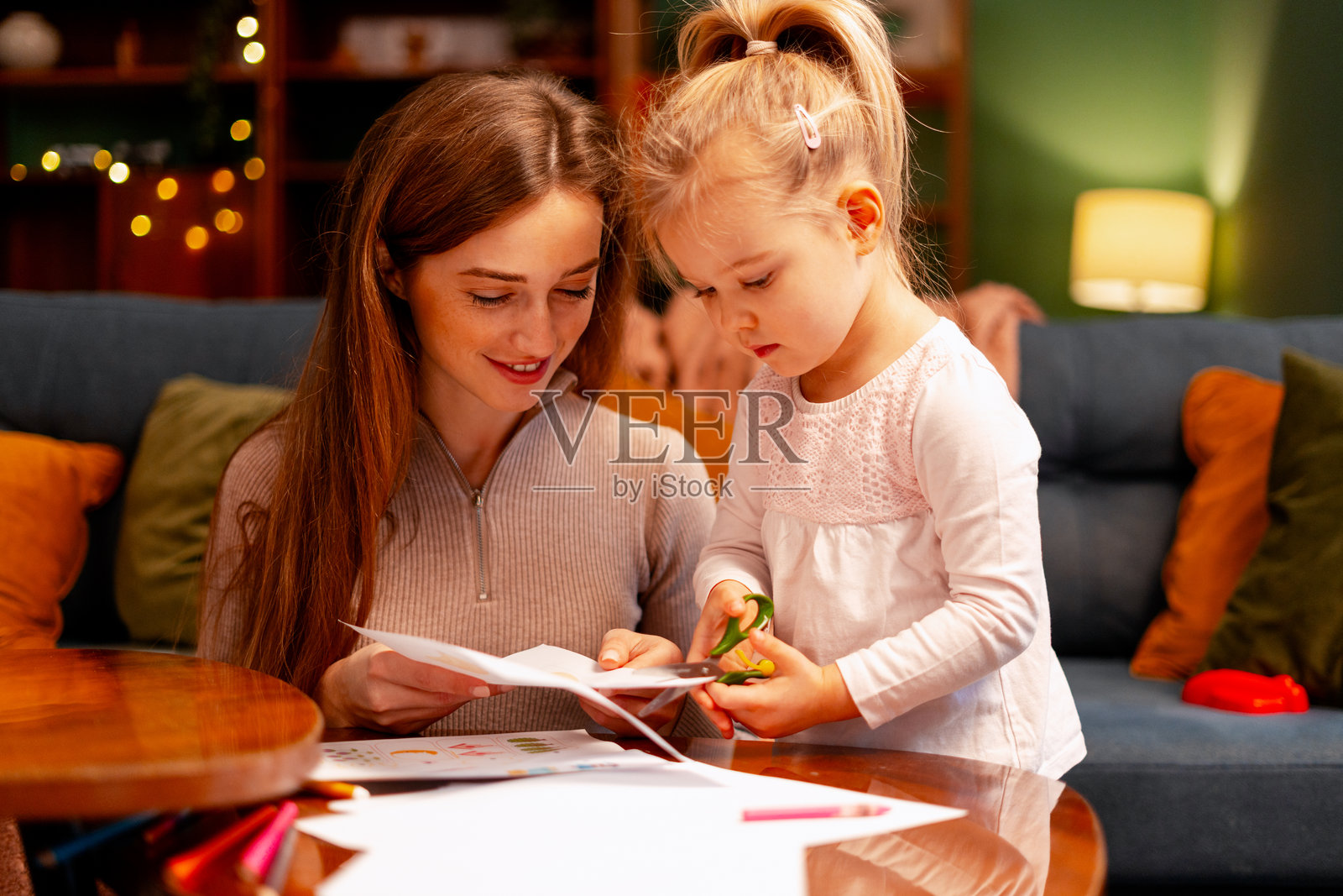 母亲和女儿在家一起剪纸,享受创意学习的乐趣照片摄影图片