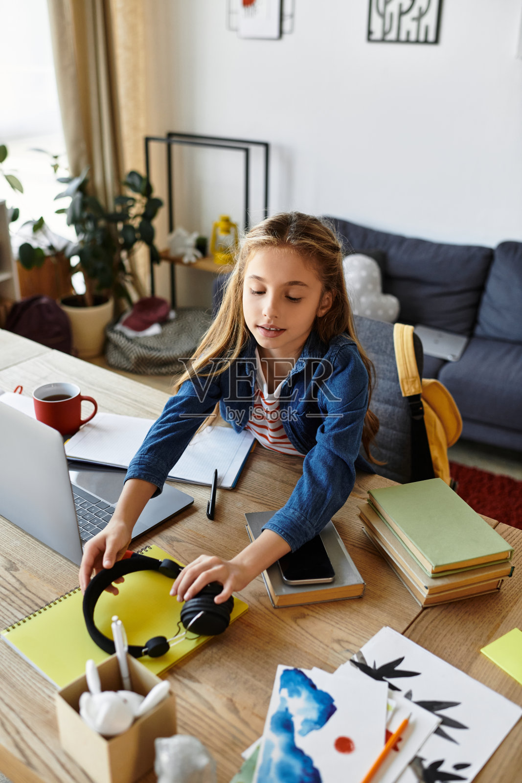 女孩在家舒适的环境中,通过笔记本电脑享受学习的时光照片摄影图片