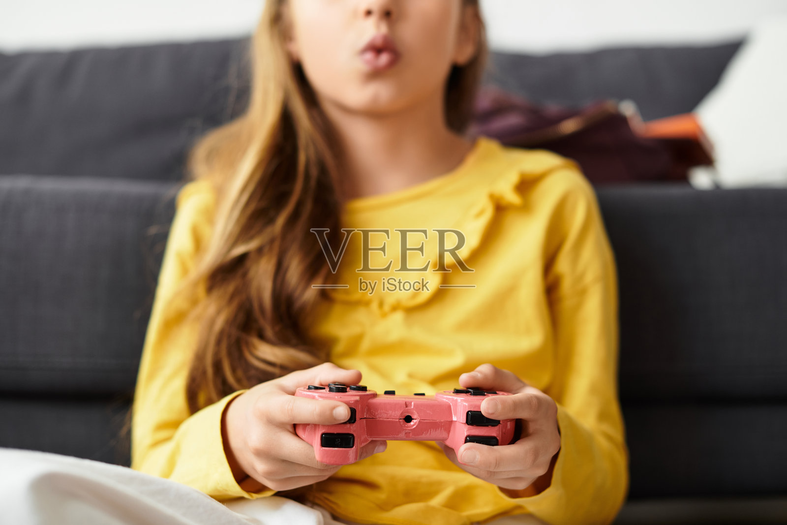 一个女孩在家舒适的客厅里享受游戏时光照片摄影图片