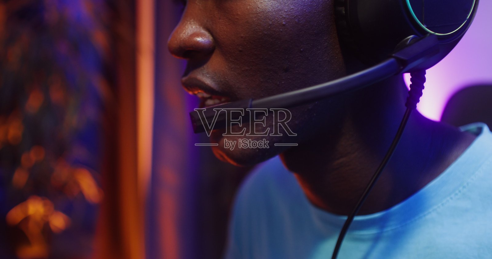 戴着耳机和麦克风玩电脑游戏的男人照片摄影图片